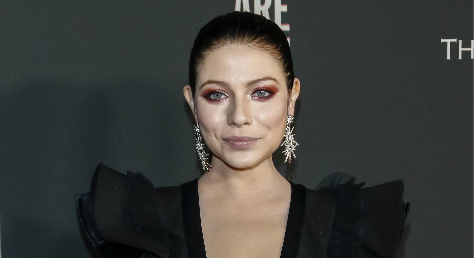 Michelle Trachtenberg wearing her hair up and posing on the red carpet