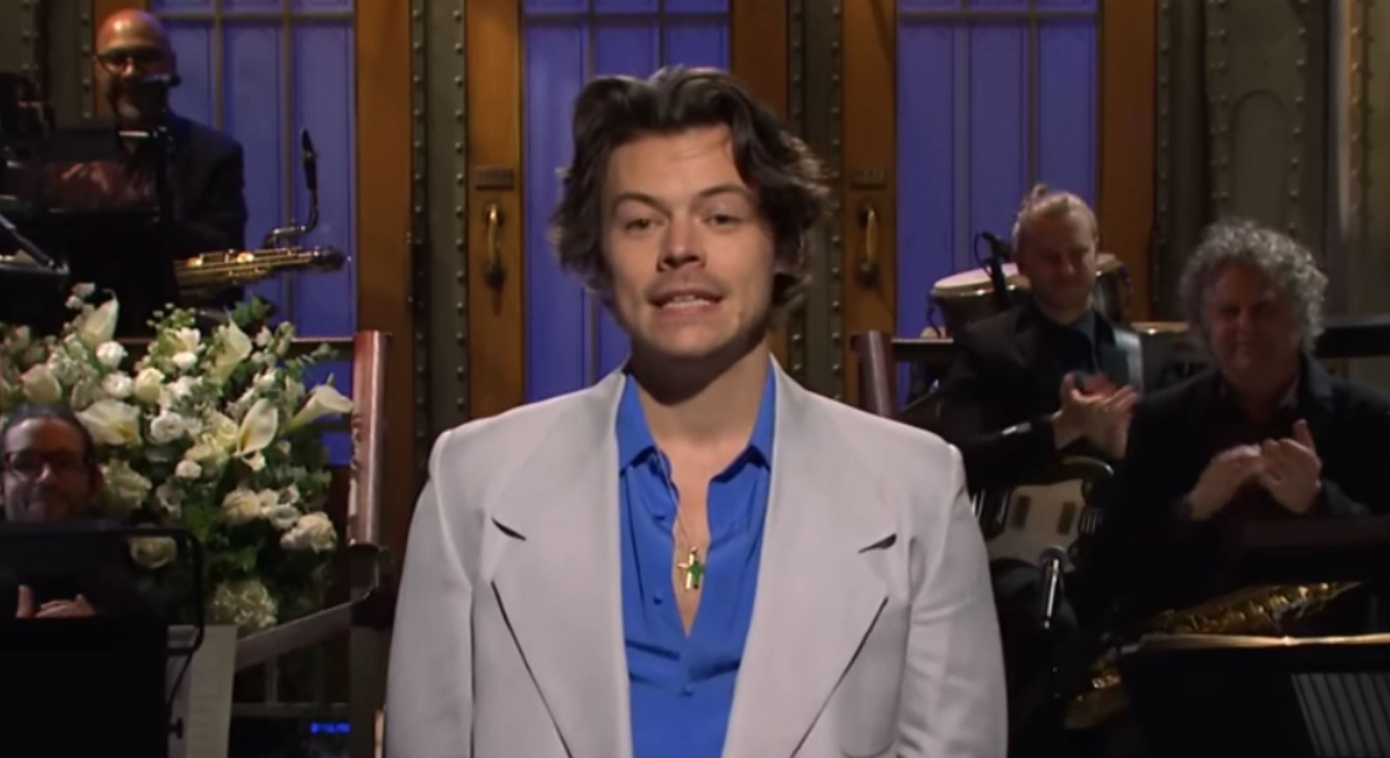 Harry Styles wears a beige suit with a blue shirt underneath on SNL