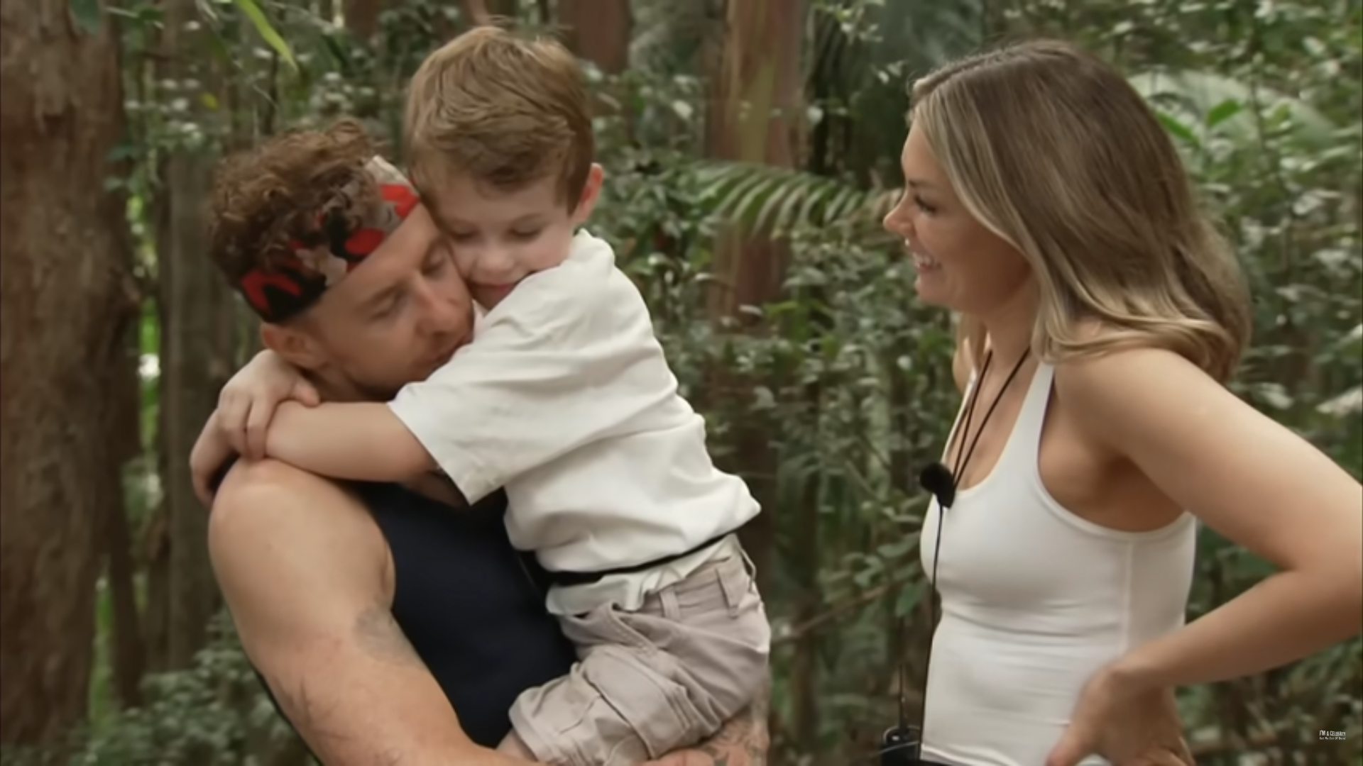 Danny Jones holding his son Cooper while wife Georgia smiles during I'm A Celebrity