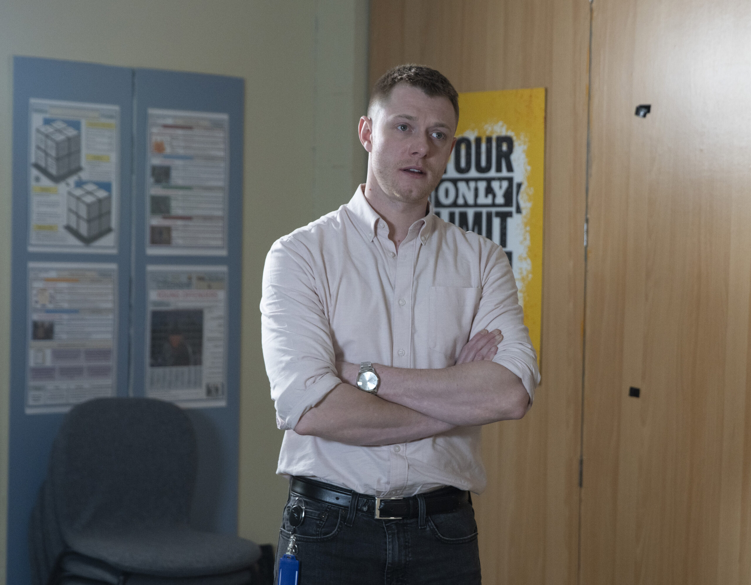 Daniel looking grumpy with his arms crossed on Corrie