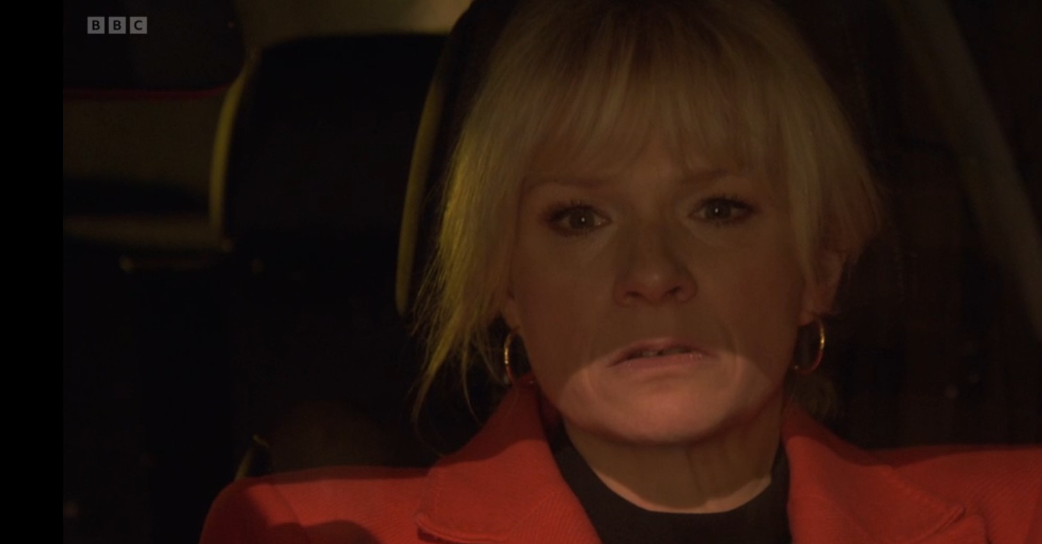 Nicola in a car on EastEnders, looking shady