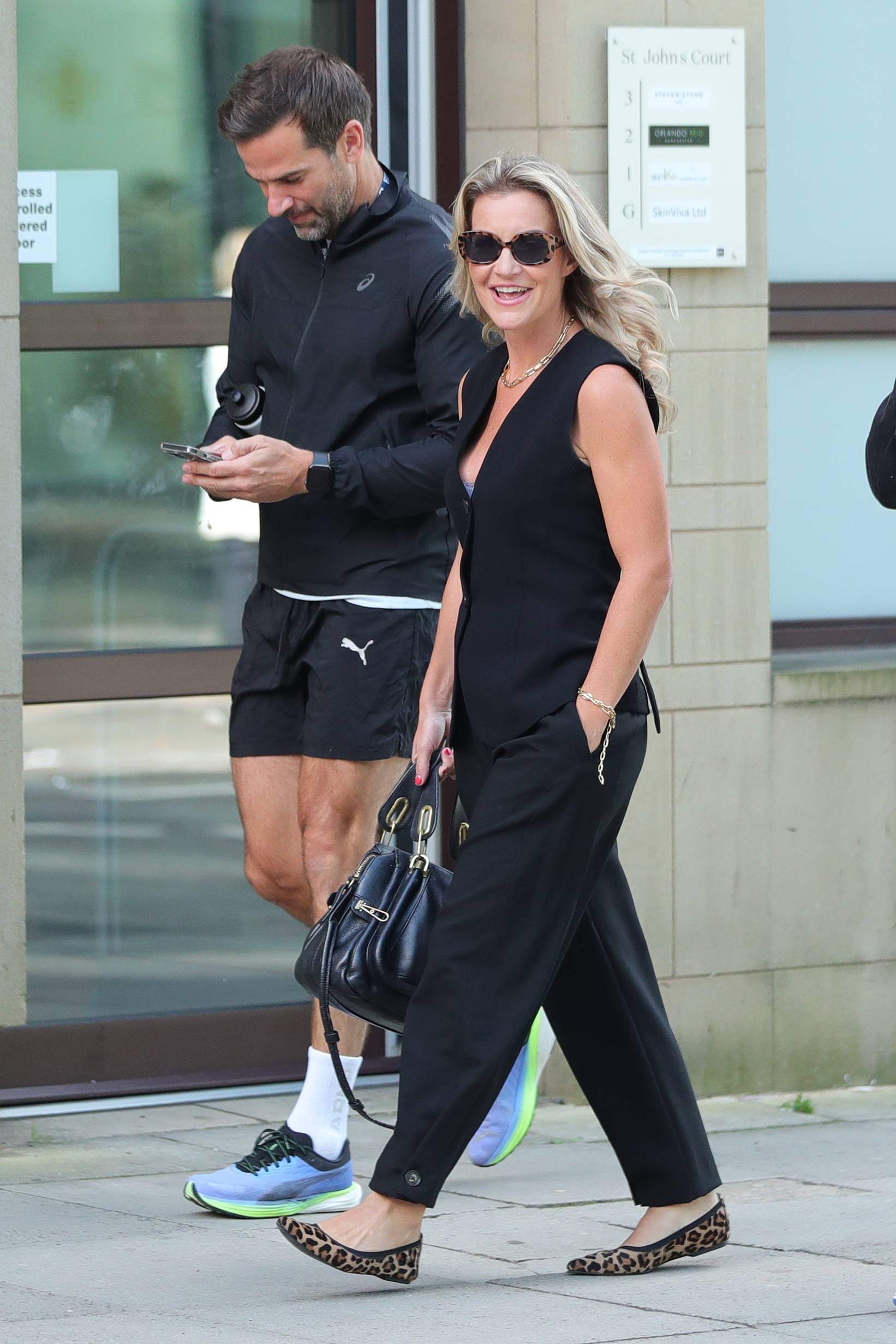 Gethin Jones and Helen Skelton walking down the street wearing black