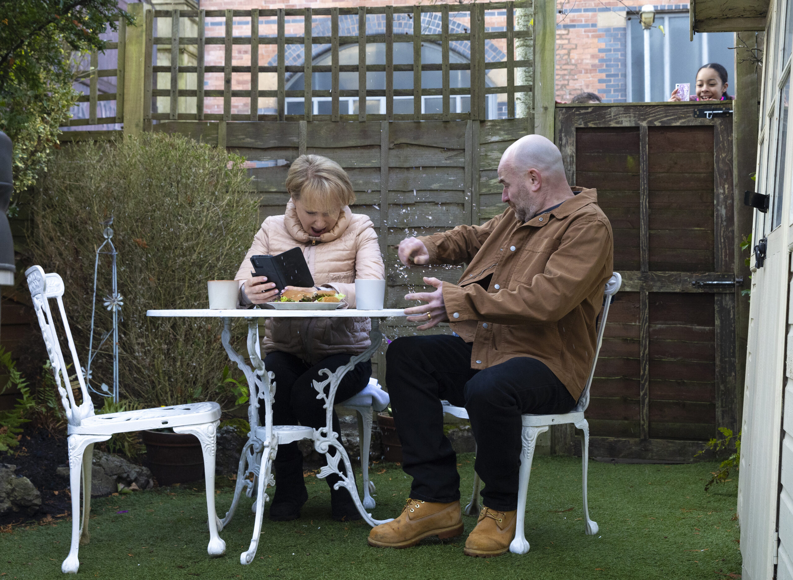 Ruby peering over fence at Sally and Tim