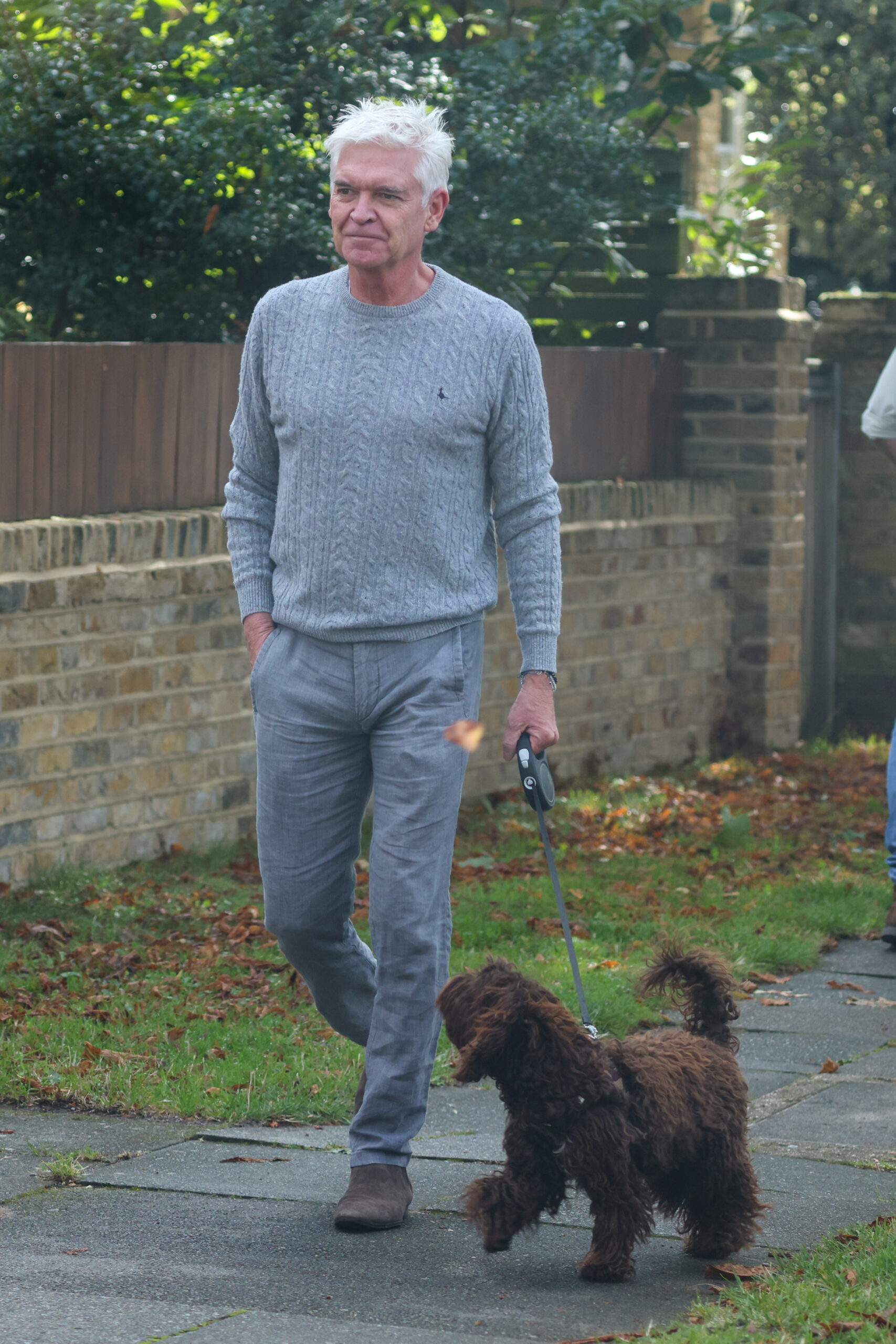 Phillip Schofield looks glum out walking dog