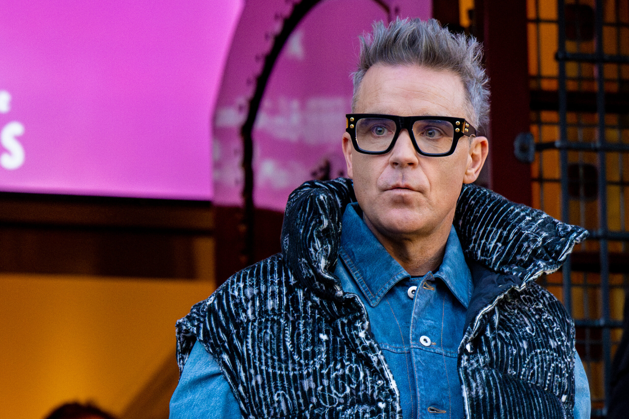 Robbie Williams wearing dark rimmed glasses