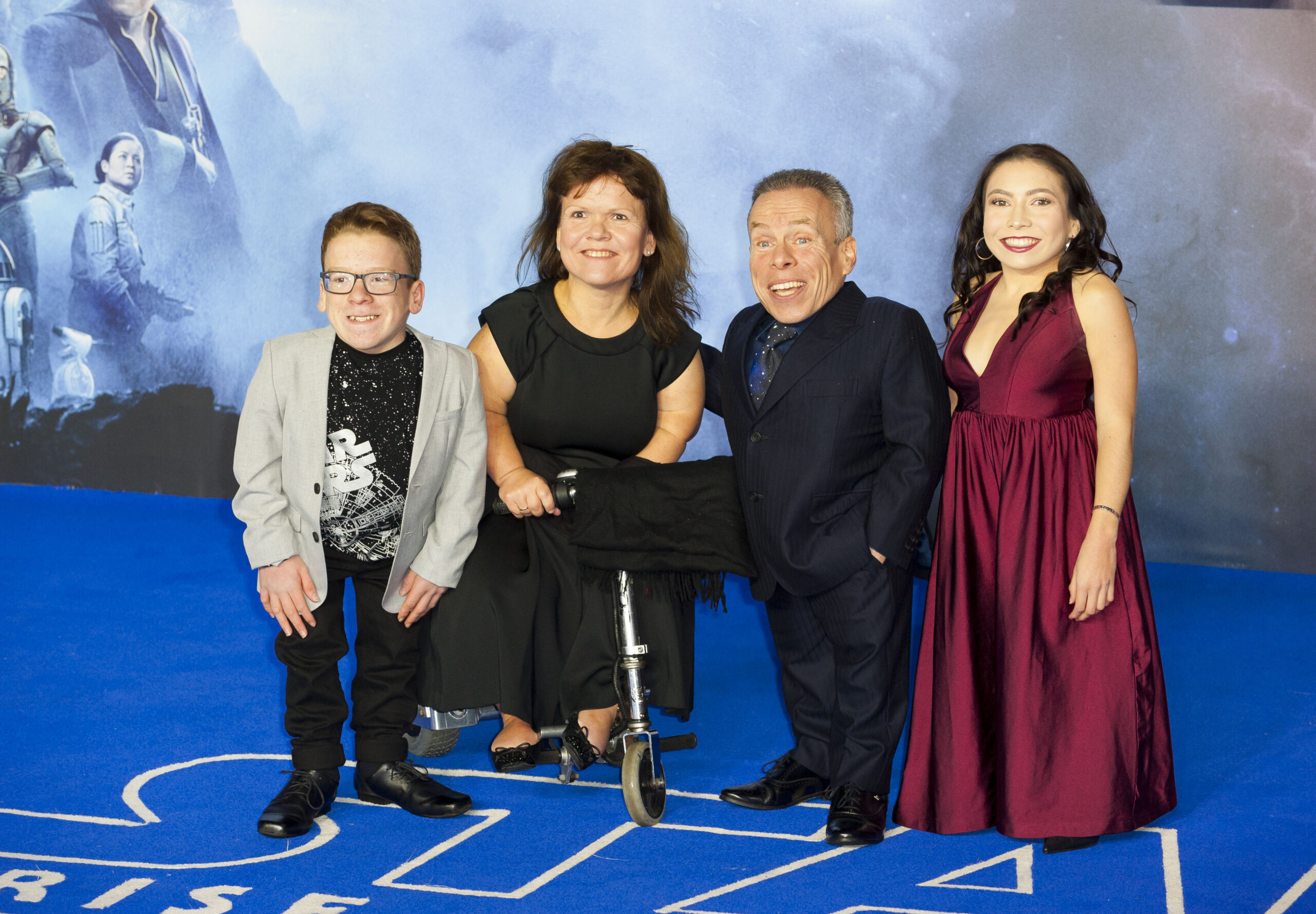 Warwick Davis with his wife and children on the blue carpet