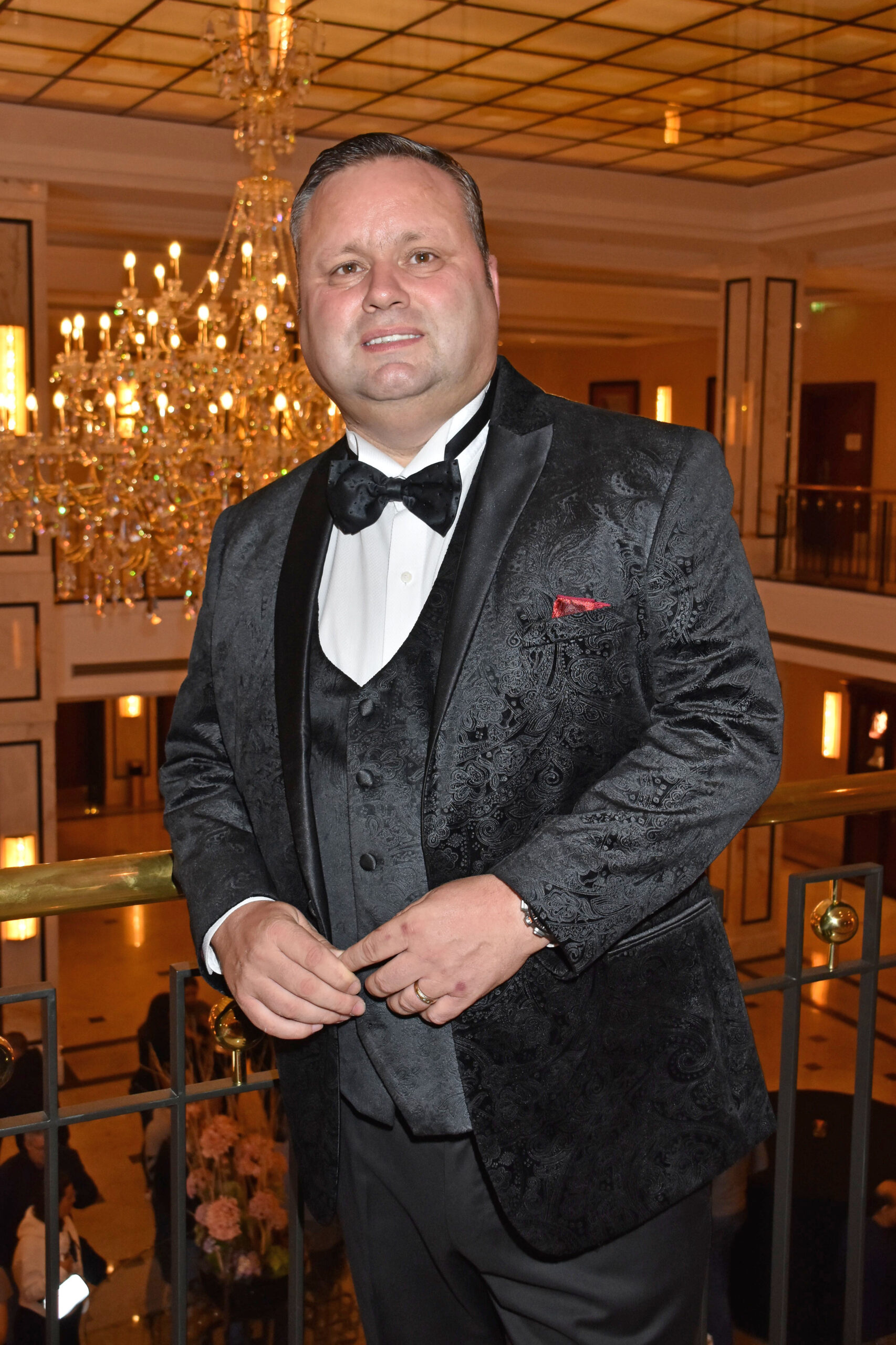 Paul Potts smiling in a black suit
