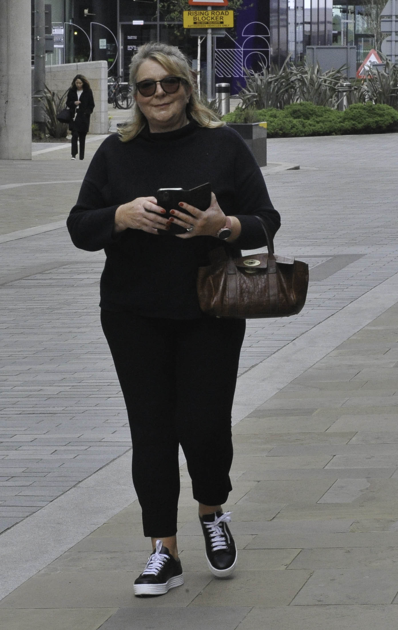Fern Britton wearing black walking down the street