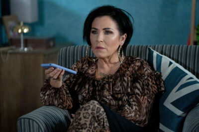Kat looks suspicious with her phone in hand on EastEnders