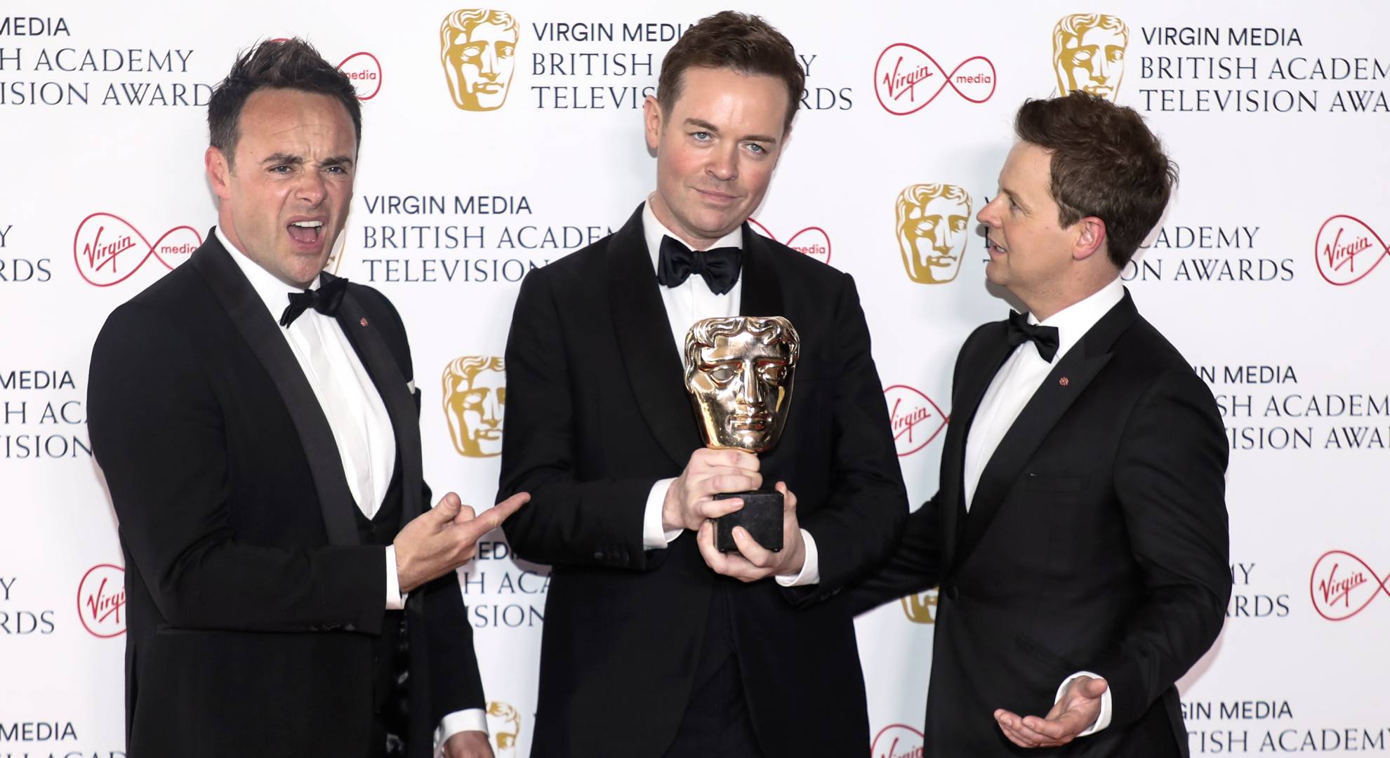 Stephen Mulhern holds an award as Ant and Dec react