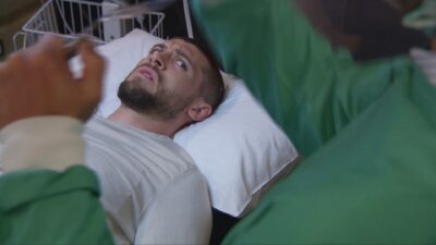 Joe lying on a hospital bed
