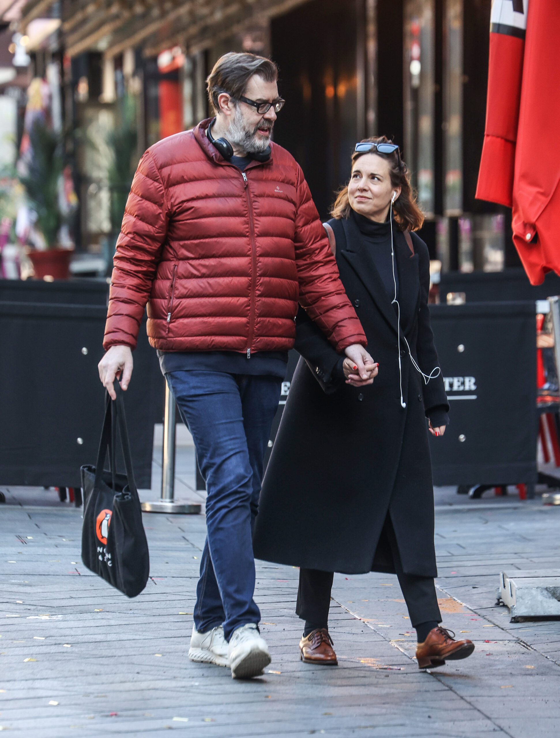 Richard Osman walking with his wife hand-in-hand