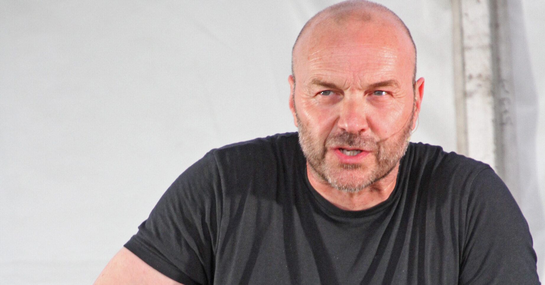 Simon Rimmer in a black T-shirt doing a cooking demonstration