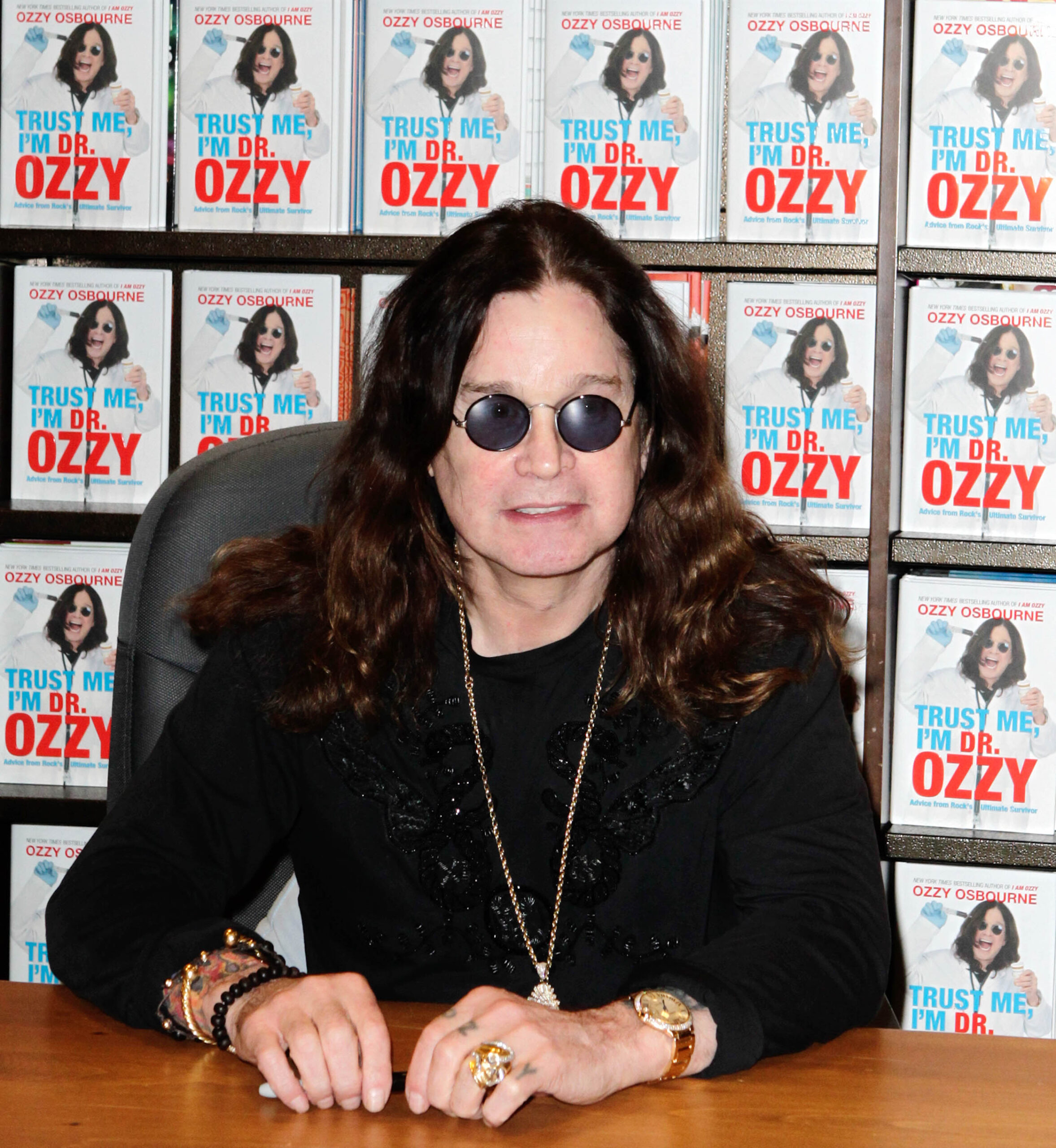 Ozzy Osbourne sitting in front of his book