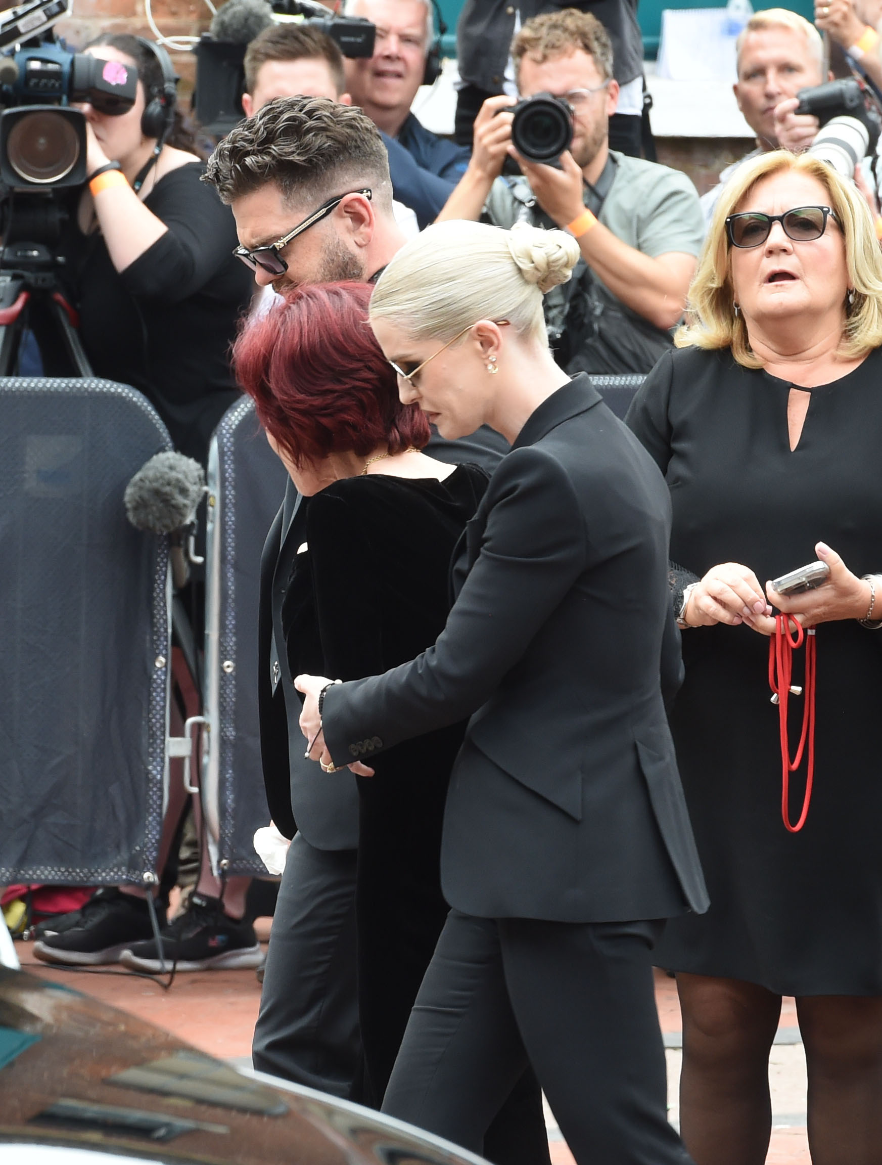 Sharon Osbourne held up by her children 