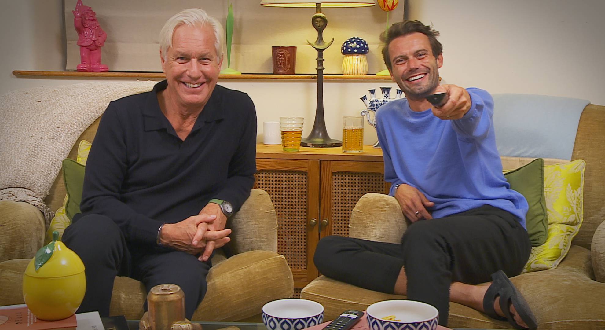 Andrew and Alfie smile and point a remote