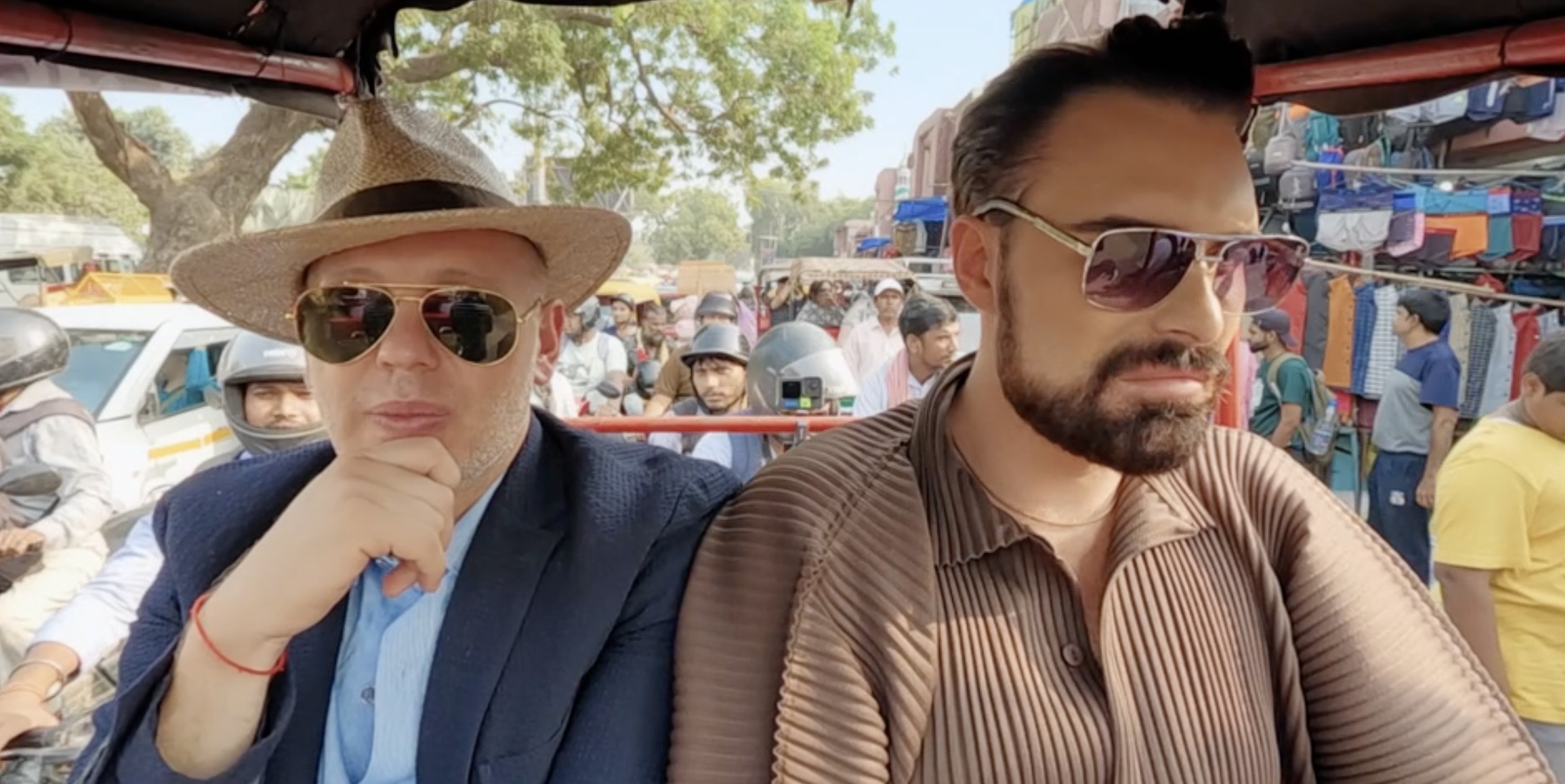 Rob Rinder and Rylan Clark sitting in a vehicle in India.