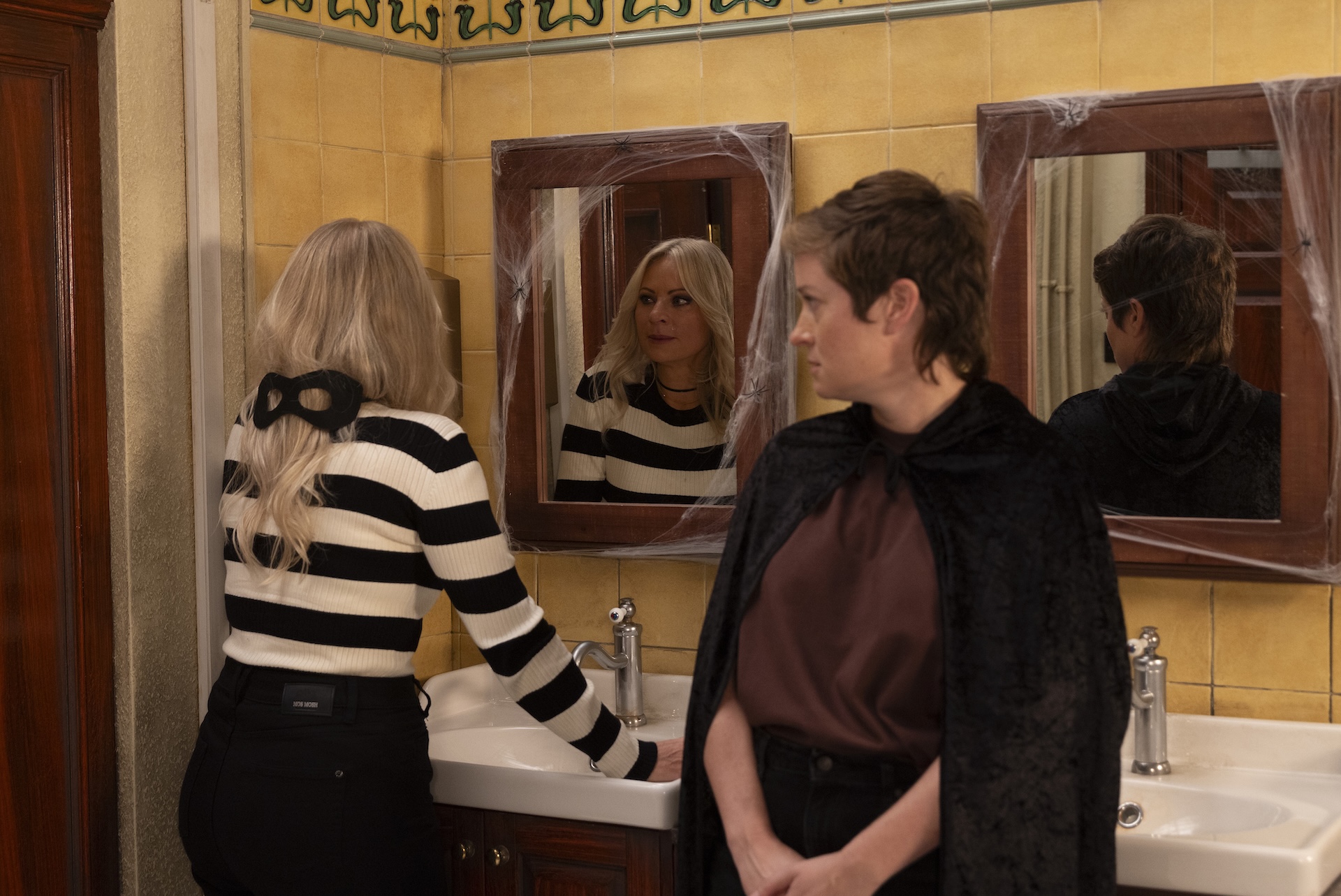 Lisa and Becky talking in the bathroom on Halloween