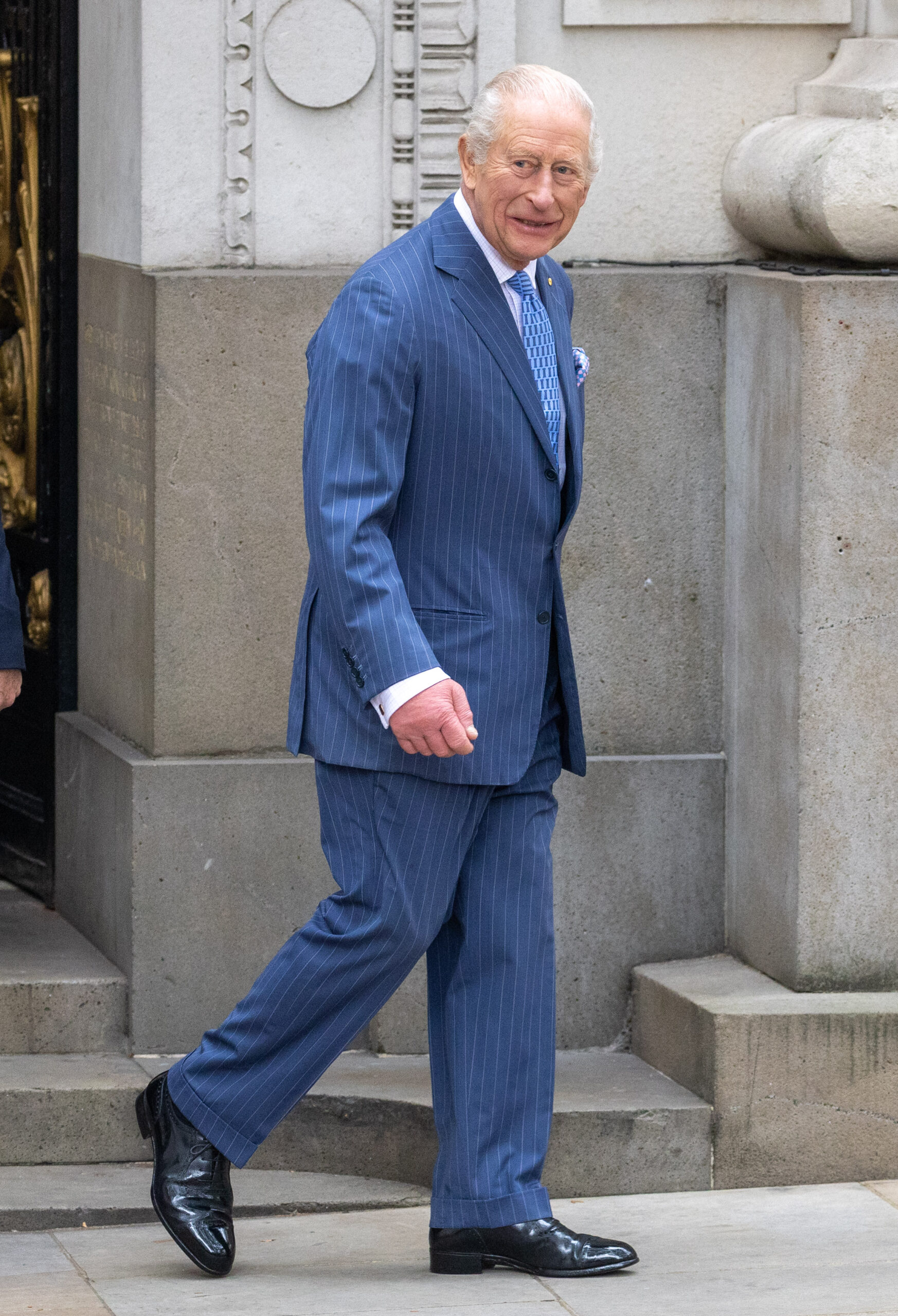 King Charles walking in blue suit outside