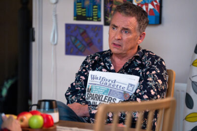 Alfie holds a newspaper on EastEnders