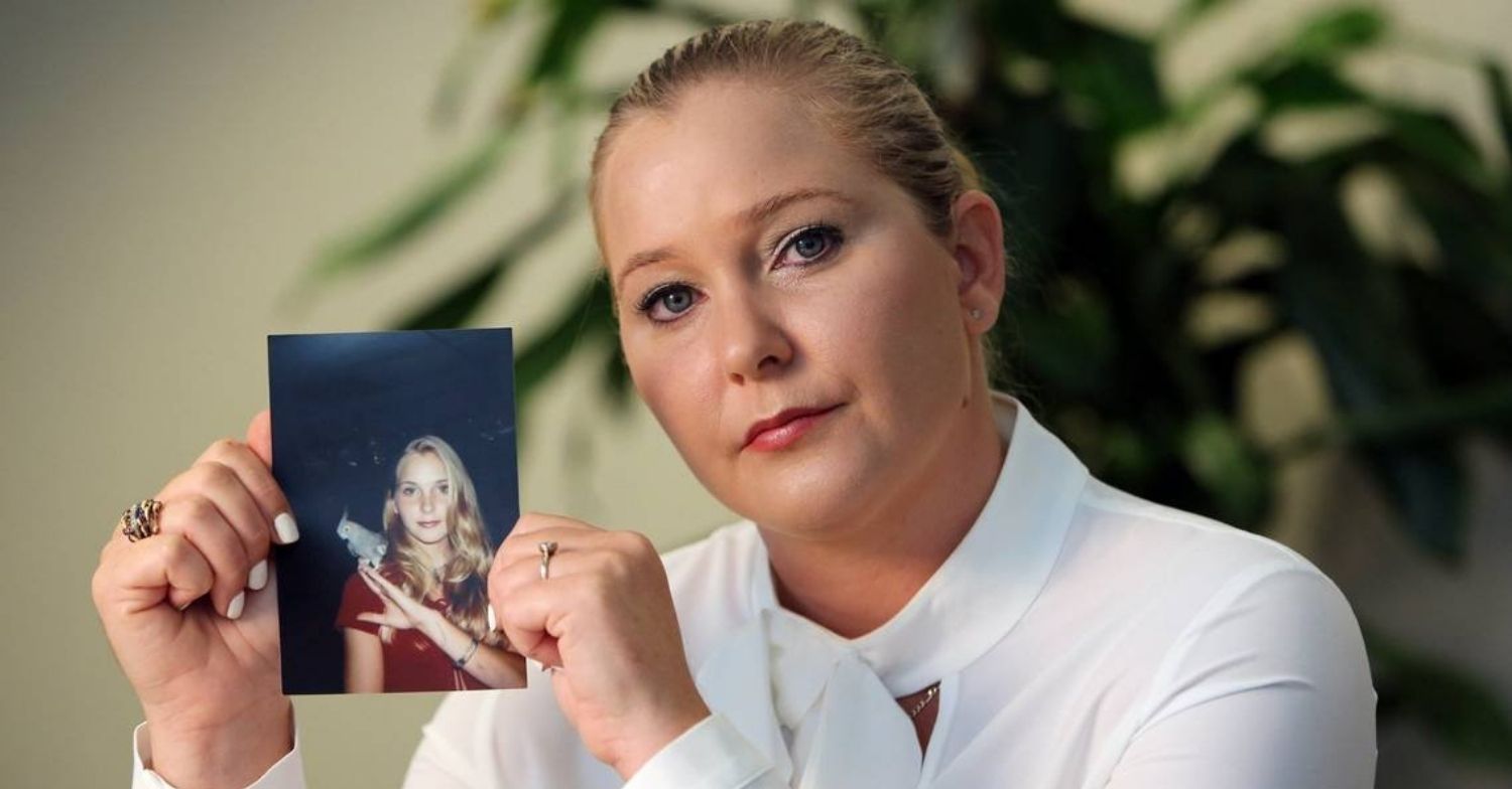 Virginia Giuffre holding up a photo of her teenage self