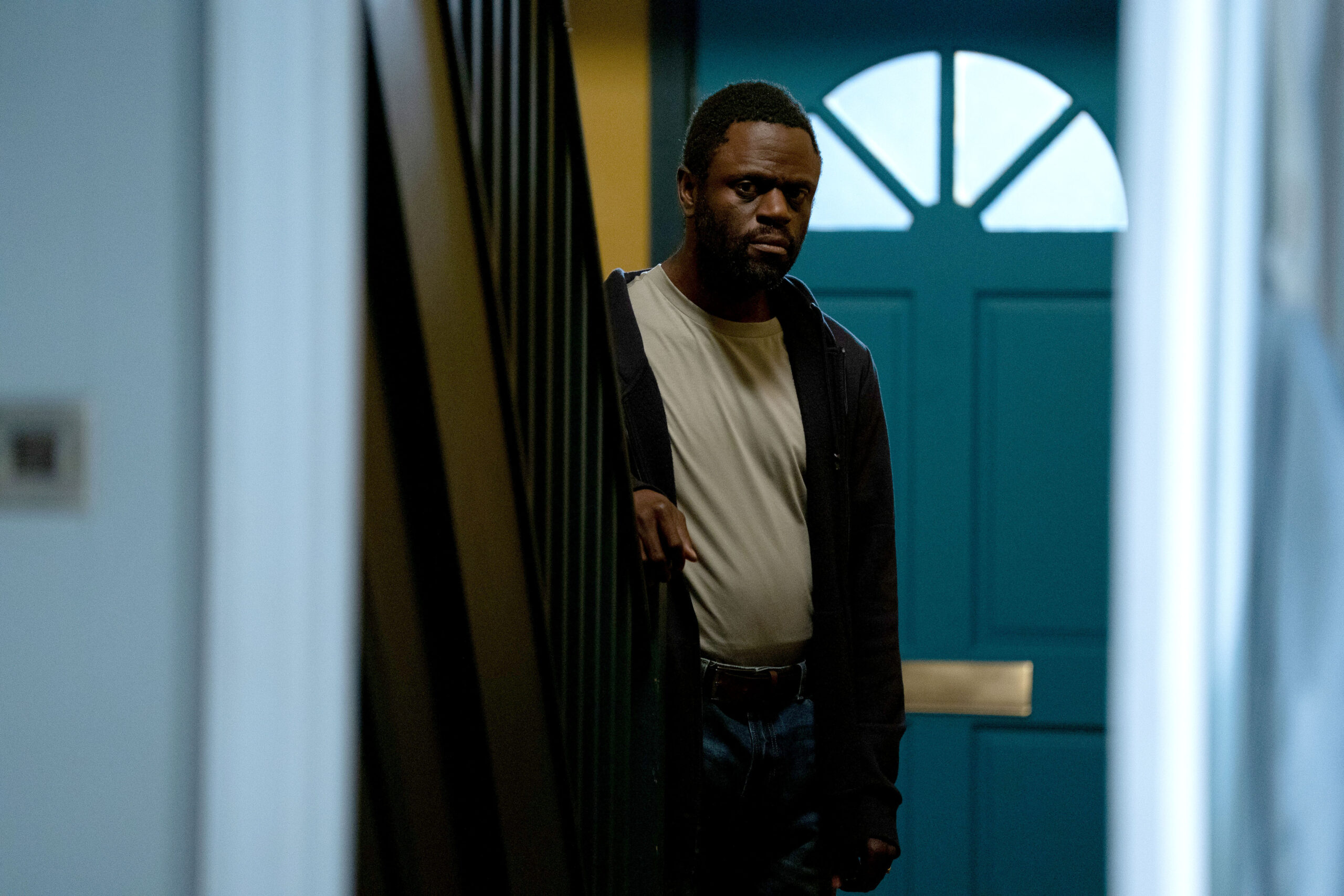 Kojo in his flat, looking worried