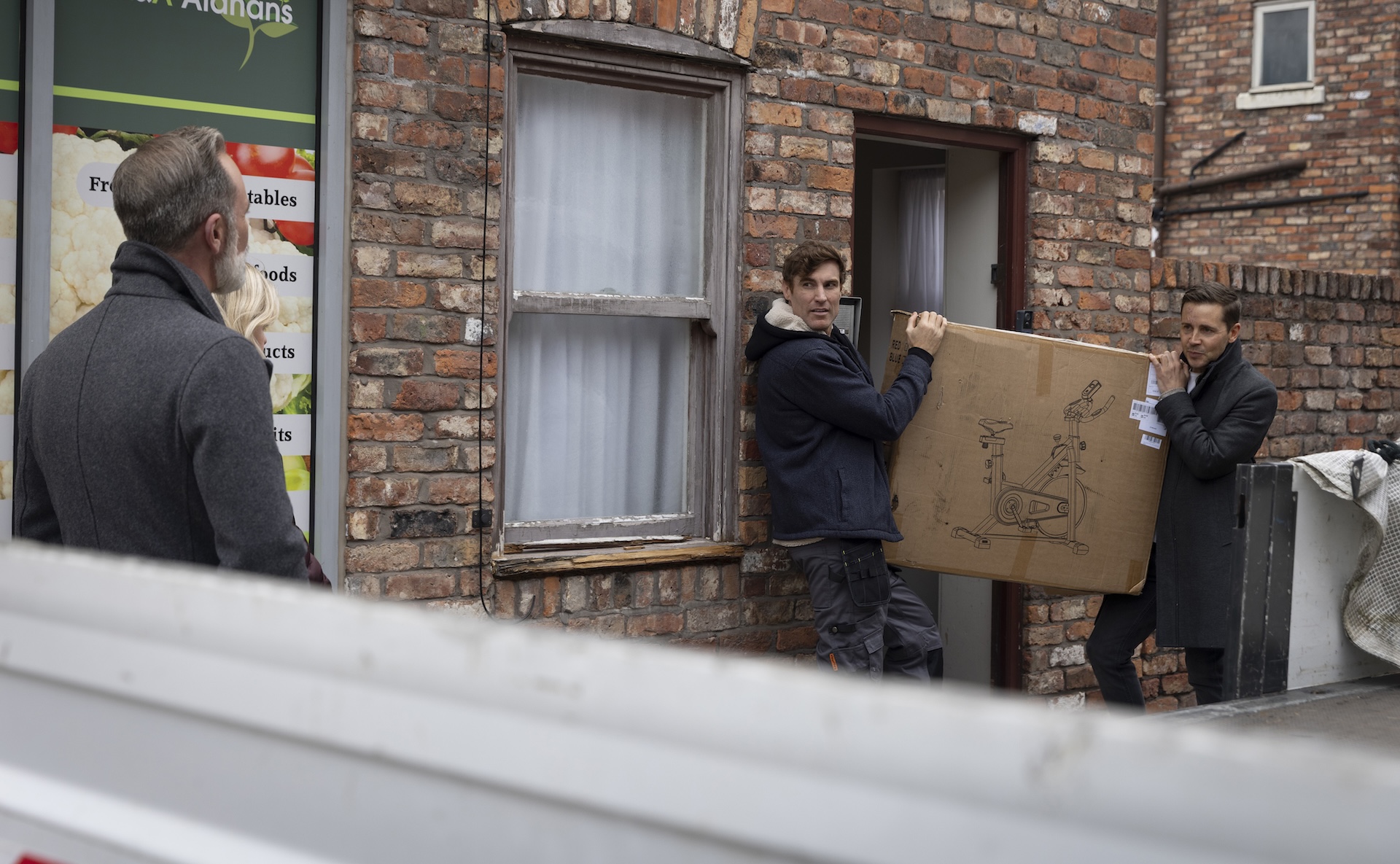Theo and Todd holding exercise bike box on Street