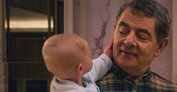 Rowan Atkinson's Trevor smiles at a baby in Man Vs Baby