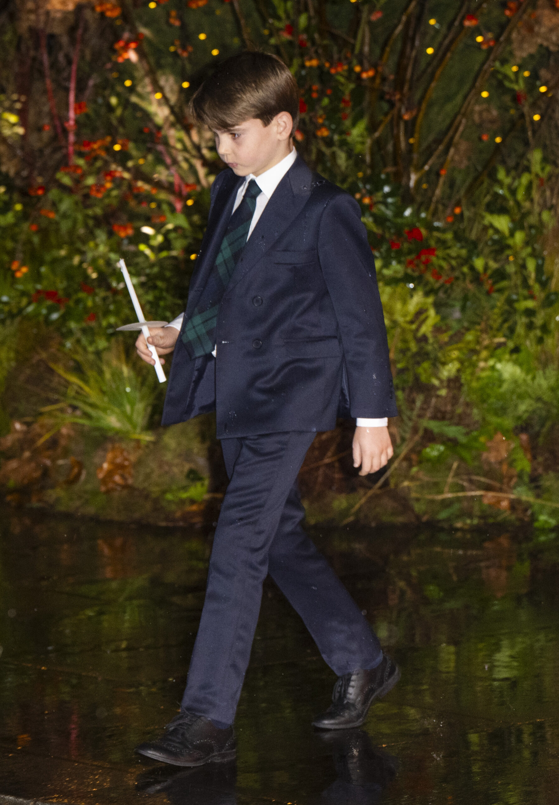 Prince Louis in suit holding a candle at Christmas carol service