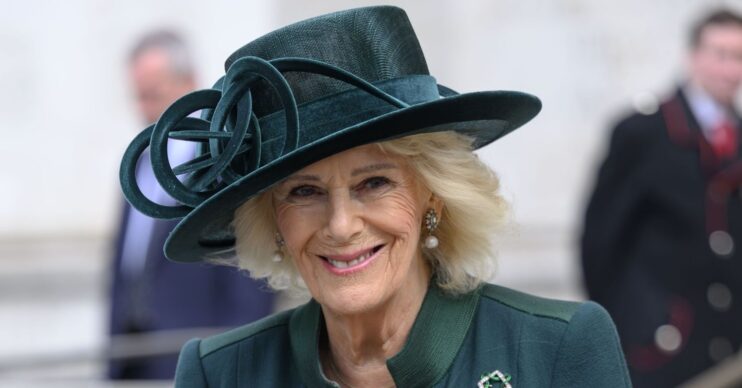 Queen Camilla smiling in green dress and hat