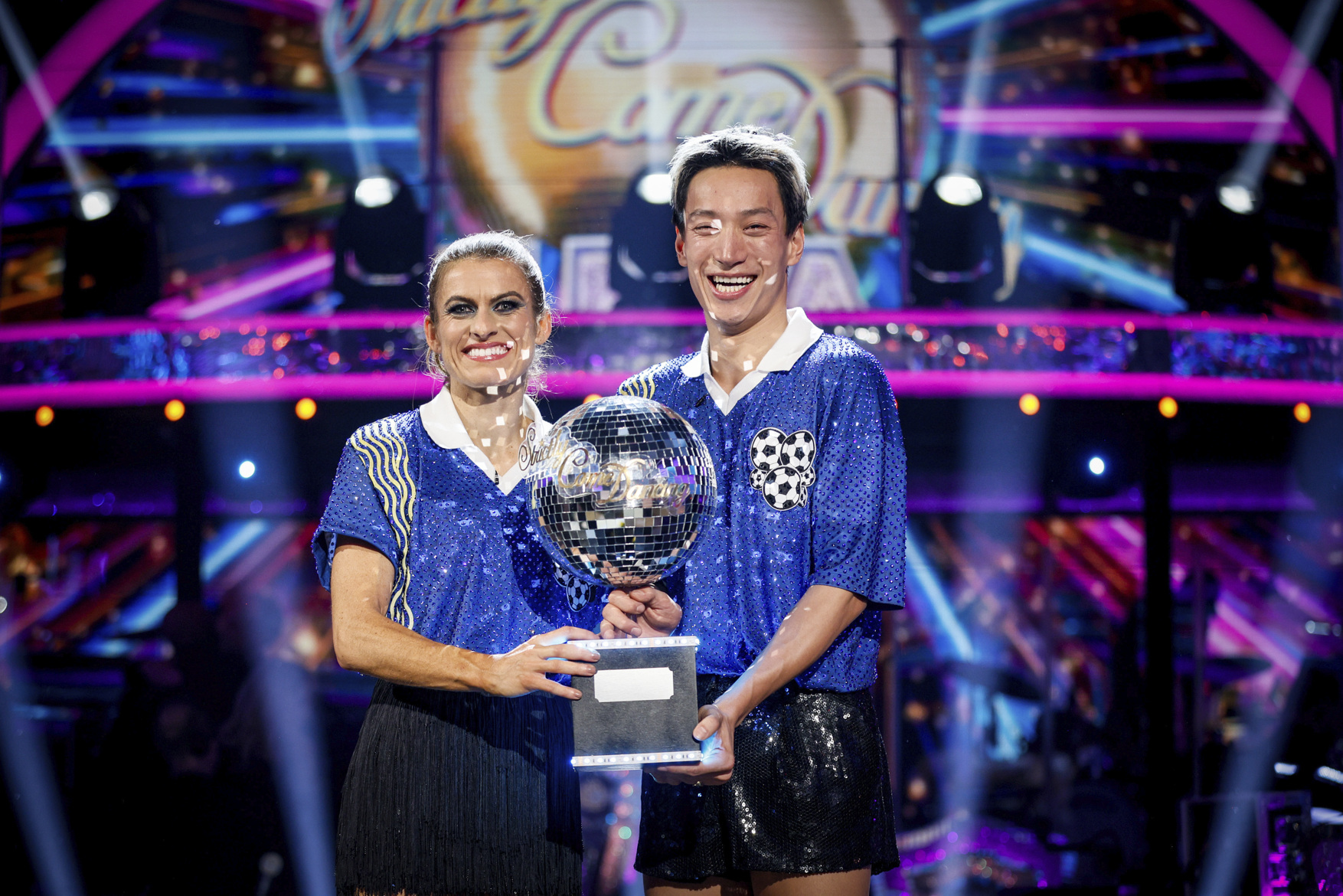 Karen and Carlos lift the glitterball trophy