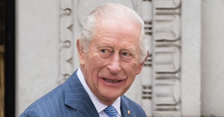 King Charles smiling in blue suit