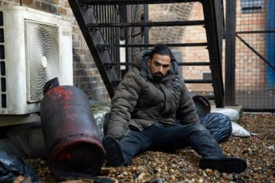 Ravi sits up looking confused in EastEnders
