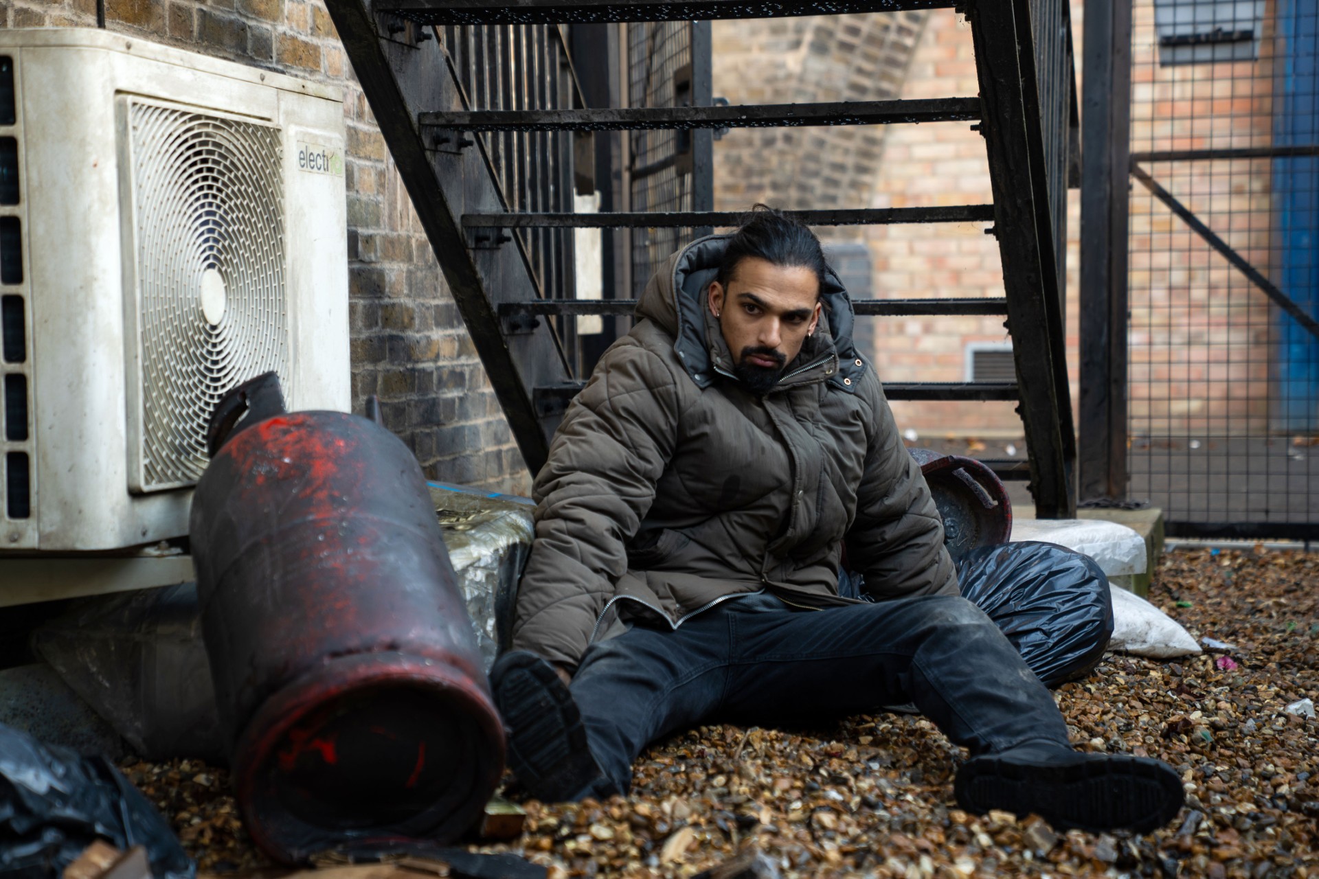 Ravi sits up looking confused in EastEnders