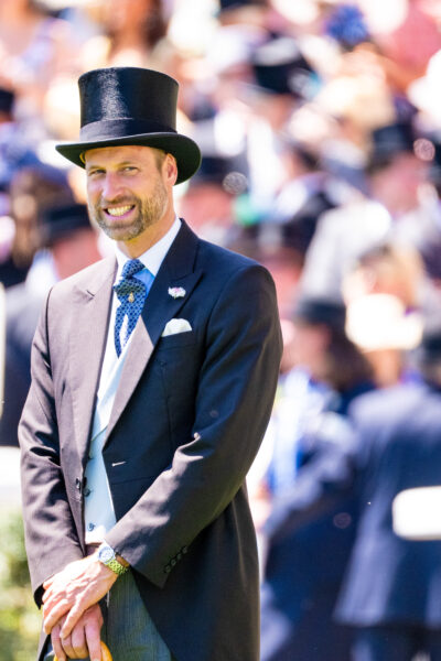 Prince William smiling wearing a top hat and suit