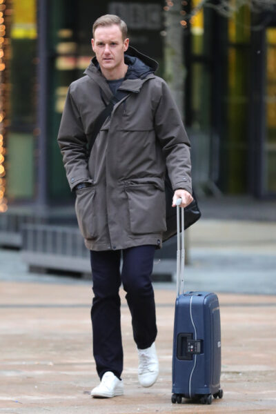 Dan Walker walking with a suitcase