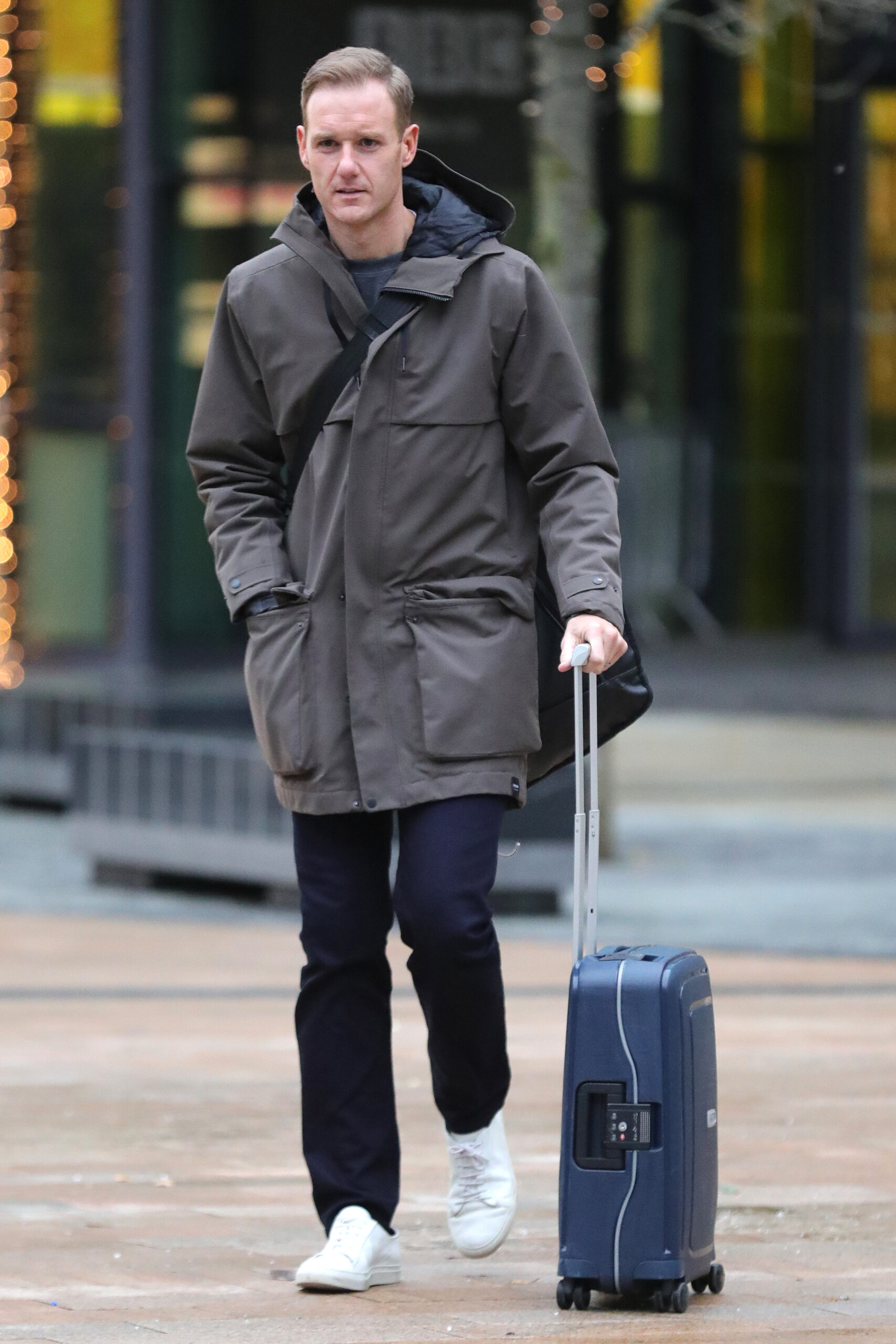Dan Walker walking with a suitcase