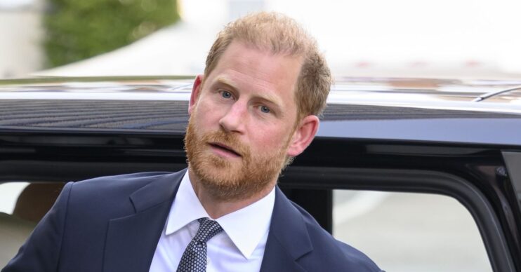 Prince Harry in suit stepping out of a car