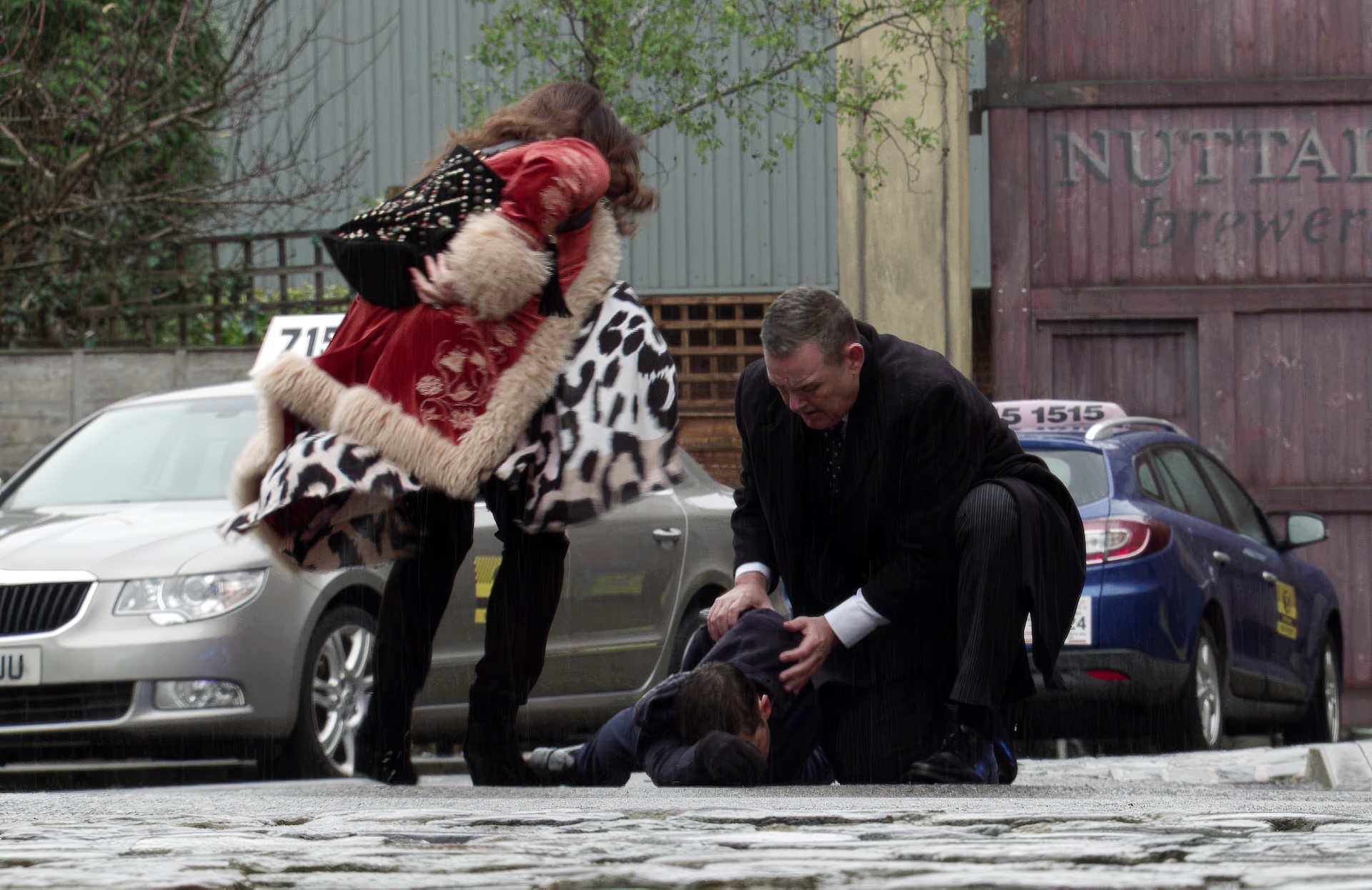 Christina and George tending to collapsed Todd on the Street