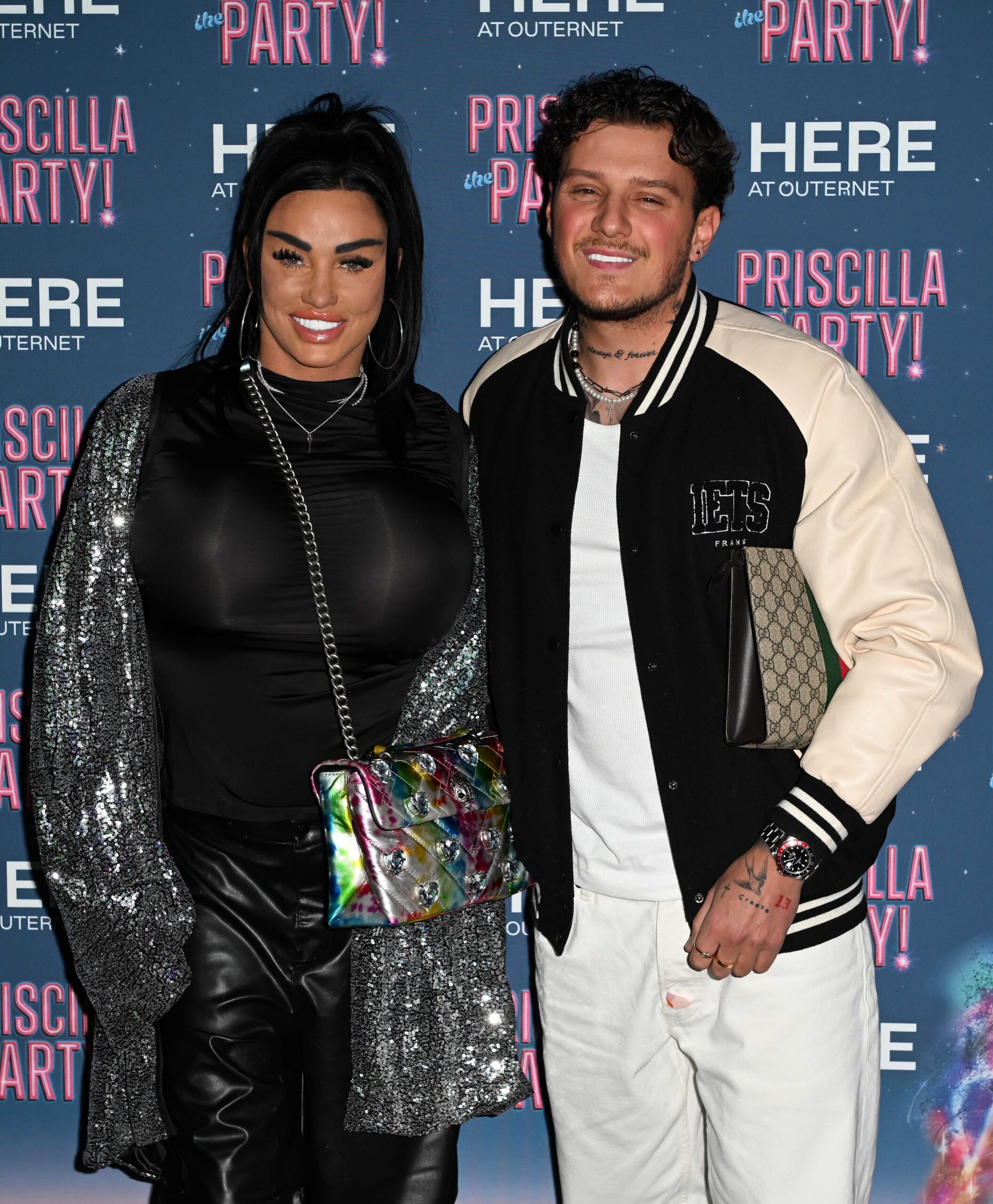 Katie and JJ posing on a red carpet 