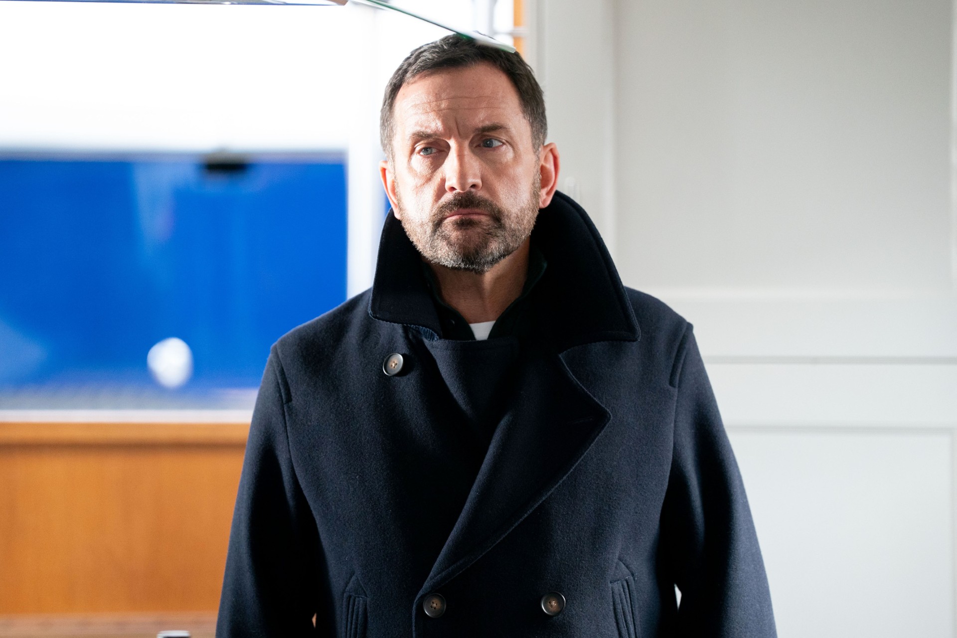 Jake in prison visiting room looking serious 