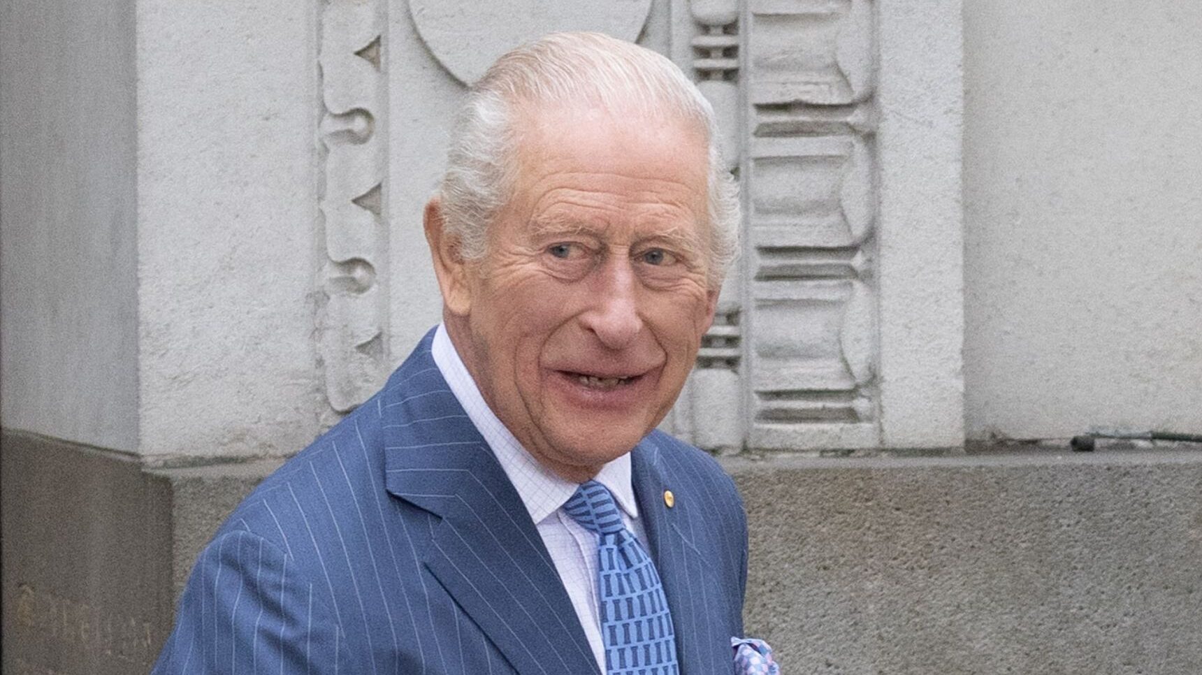 King Charles smiling in blue suit