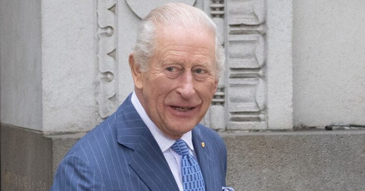 King Charles smiling in blue suit