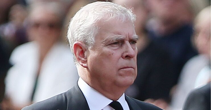 Andrew Mountbatten-Windsor frowning wearing a black suit