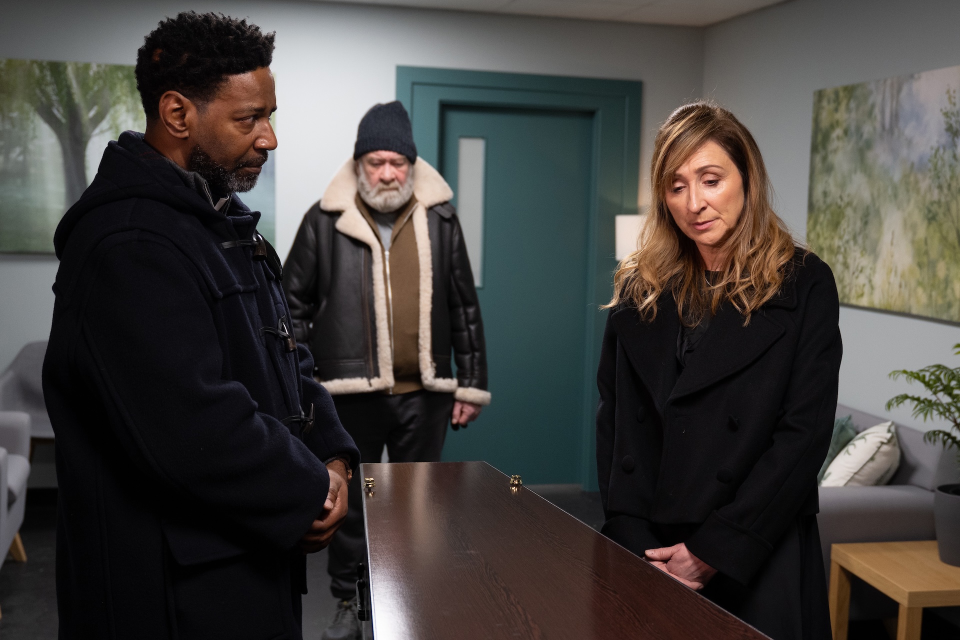 Charles Bear and Laurel look at Ray's coffin