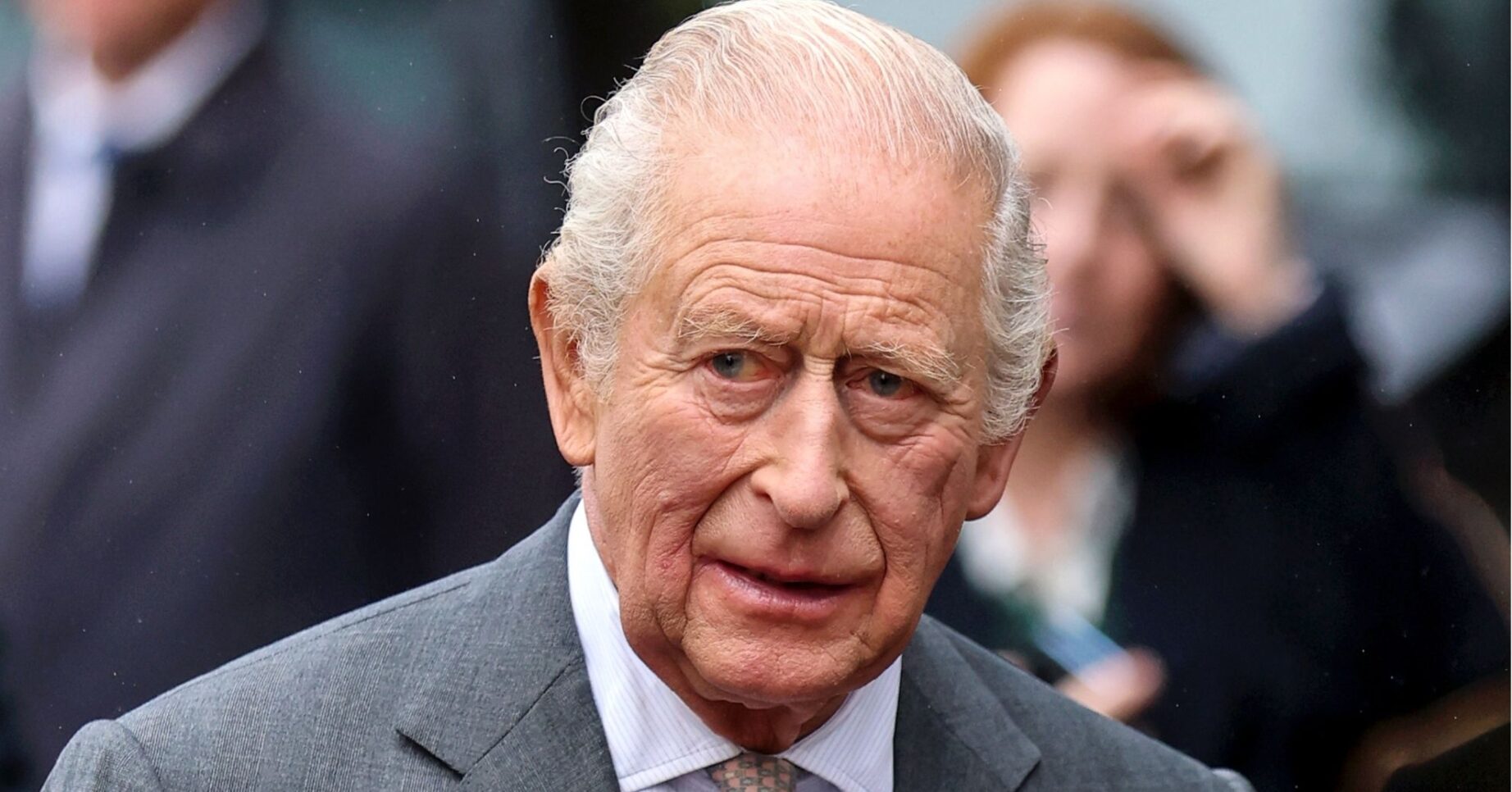 King Charles in grey suit, looking concerned