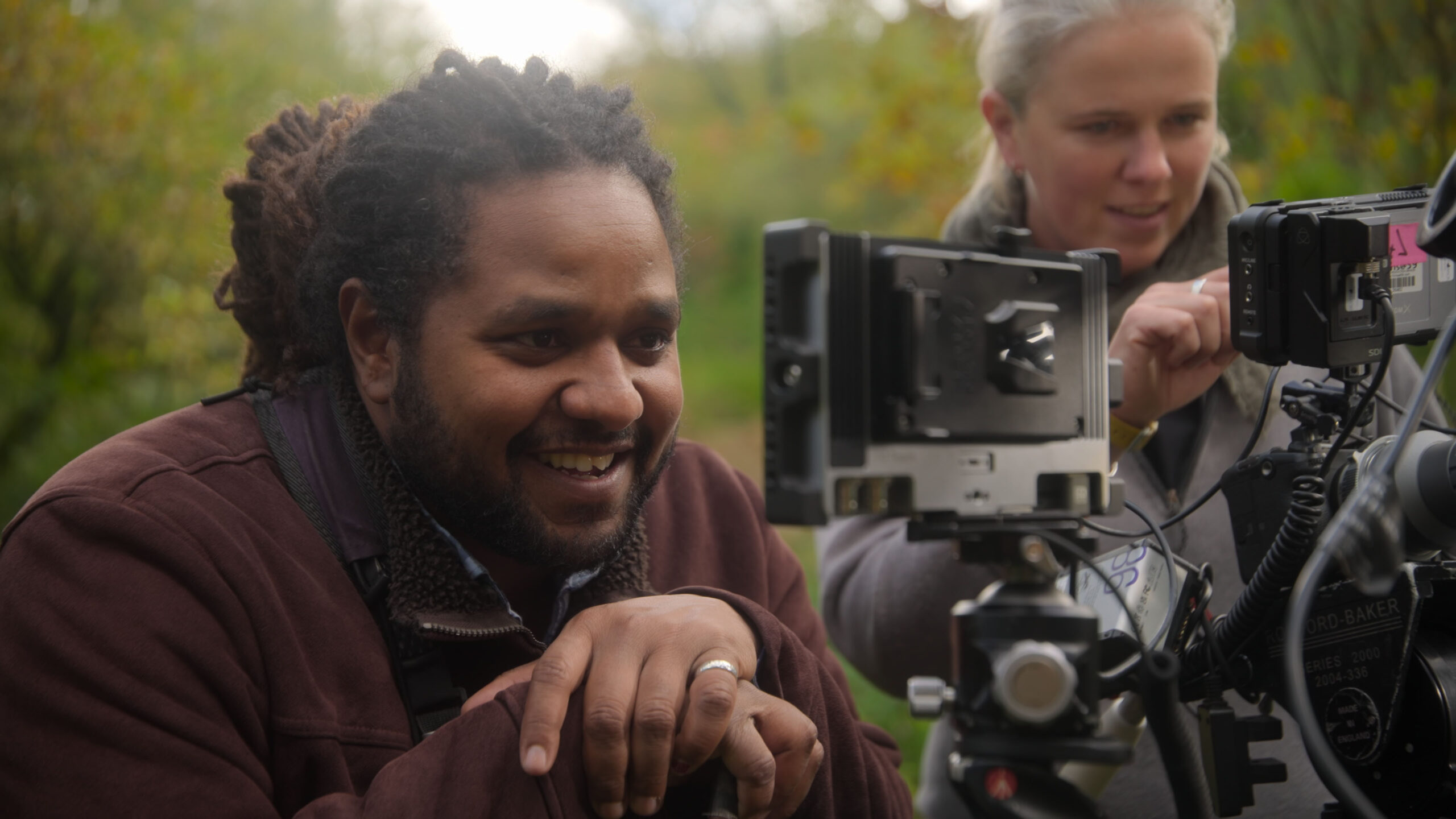 Hamza Yassin smiling looking through a camera