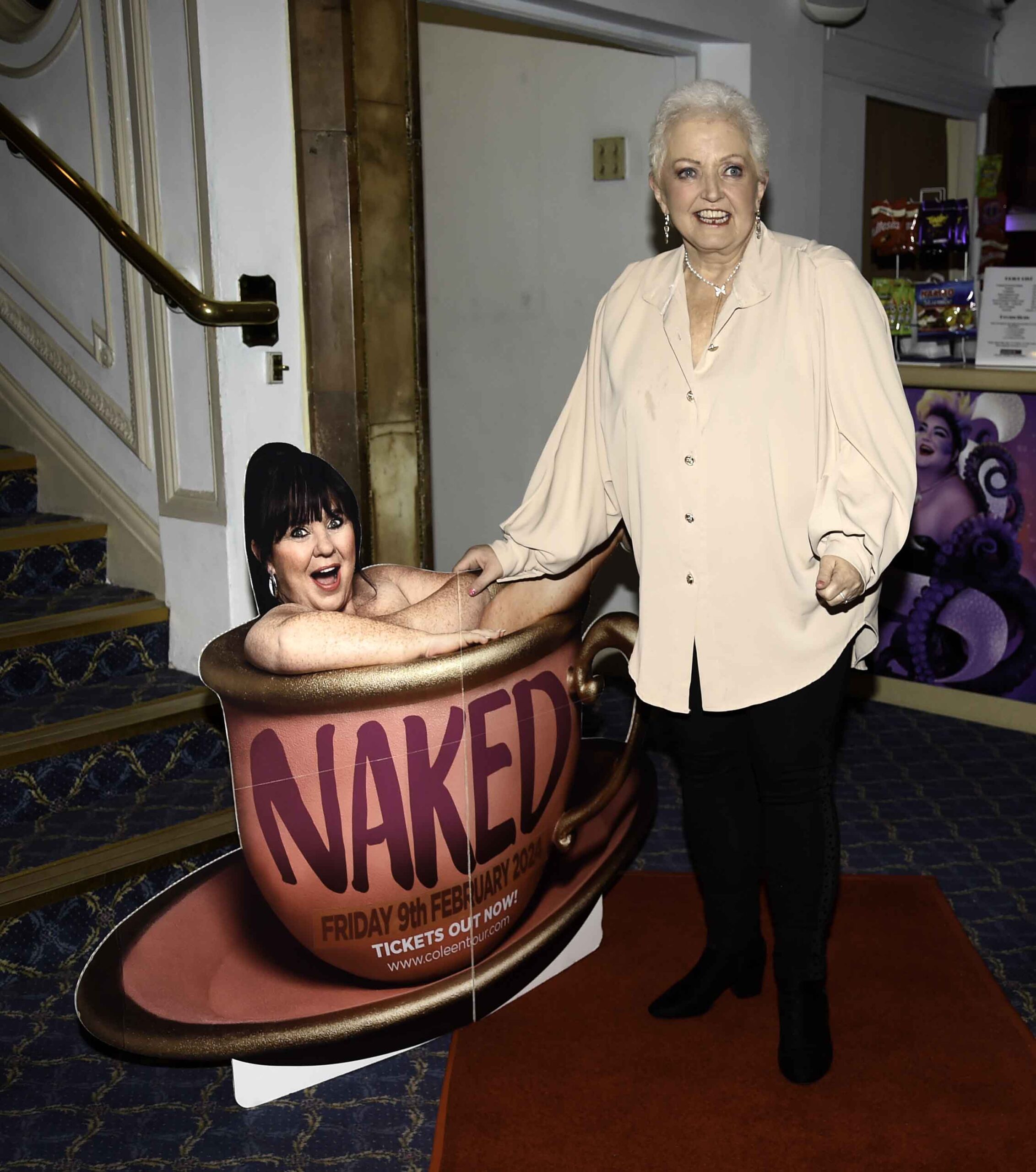 Linda Nolan smiling next to a cut-out of Coleen 