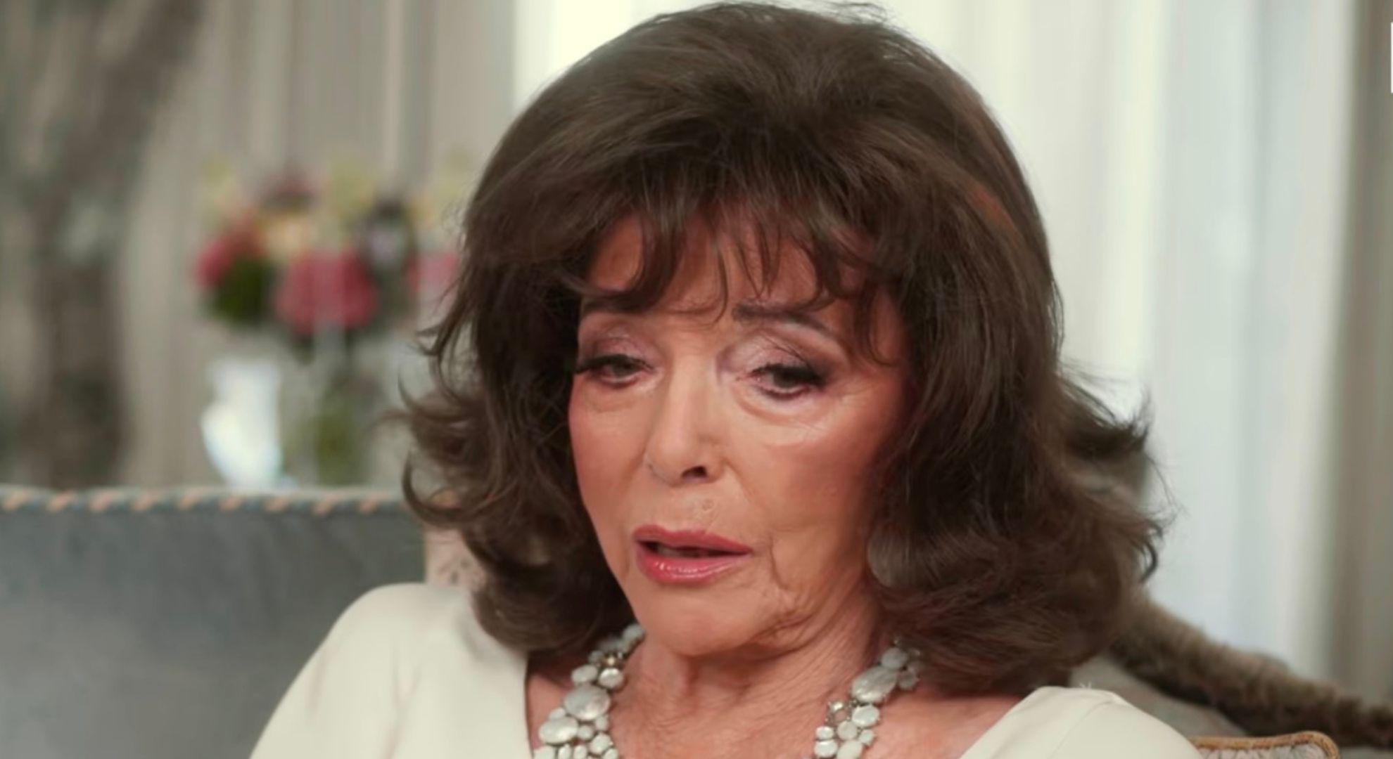 Joan Collins looking down