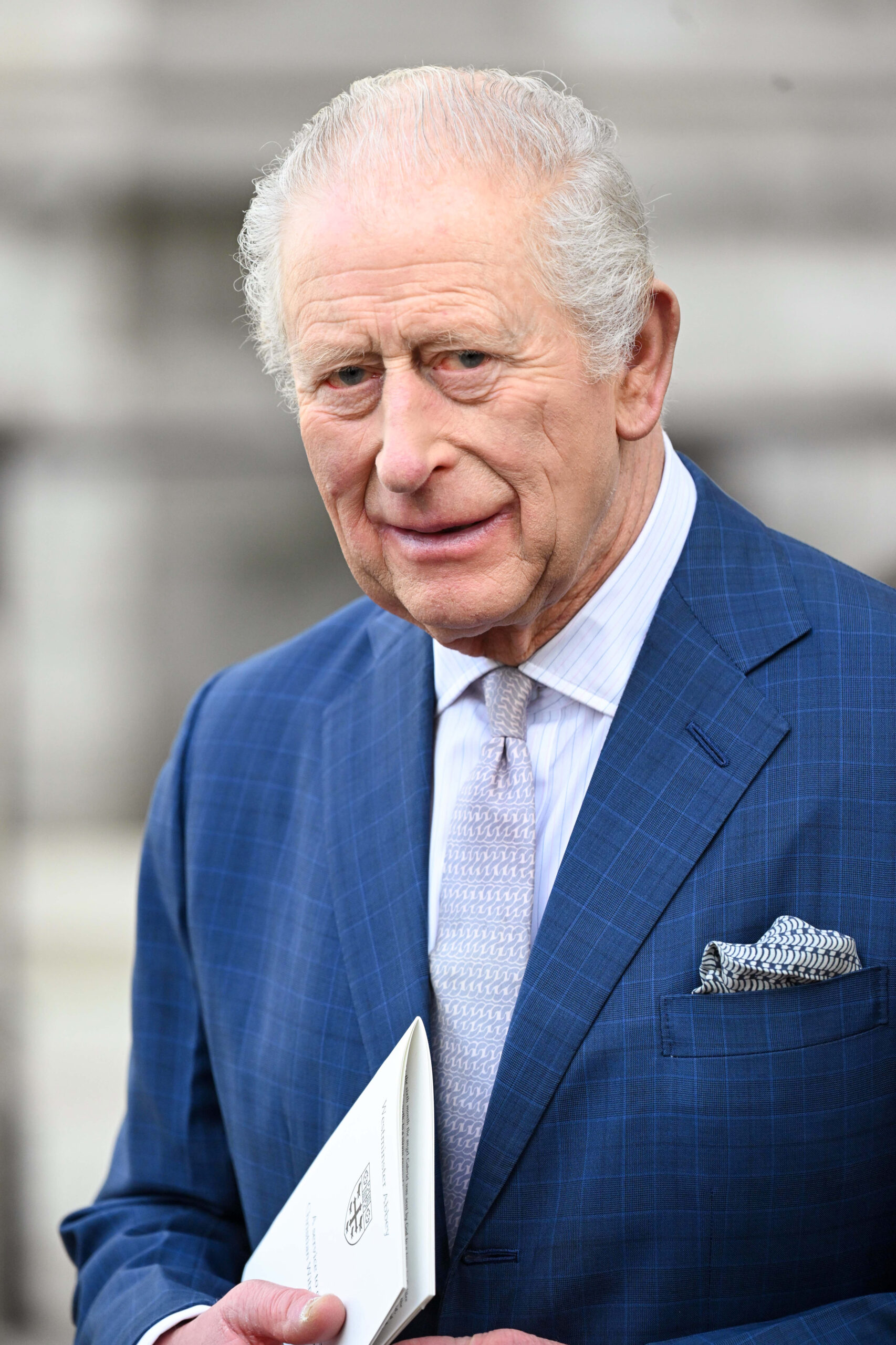 King Charles with a strained smile